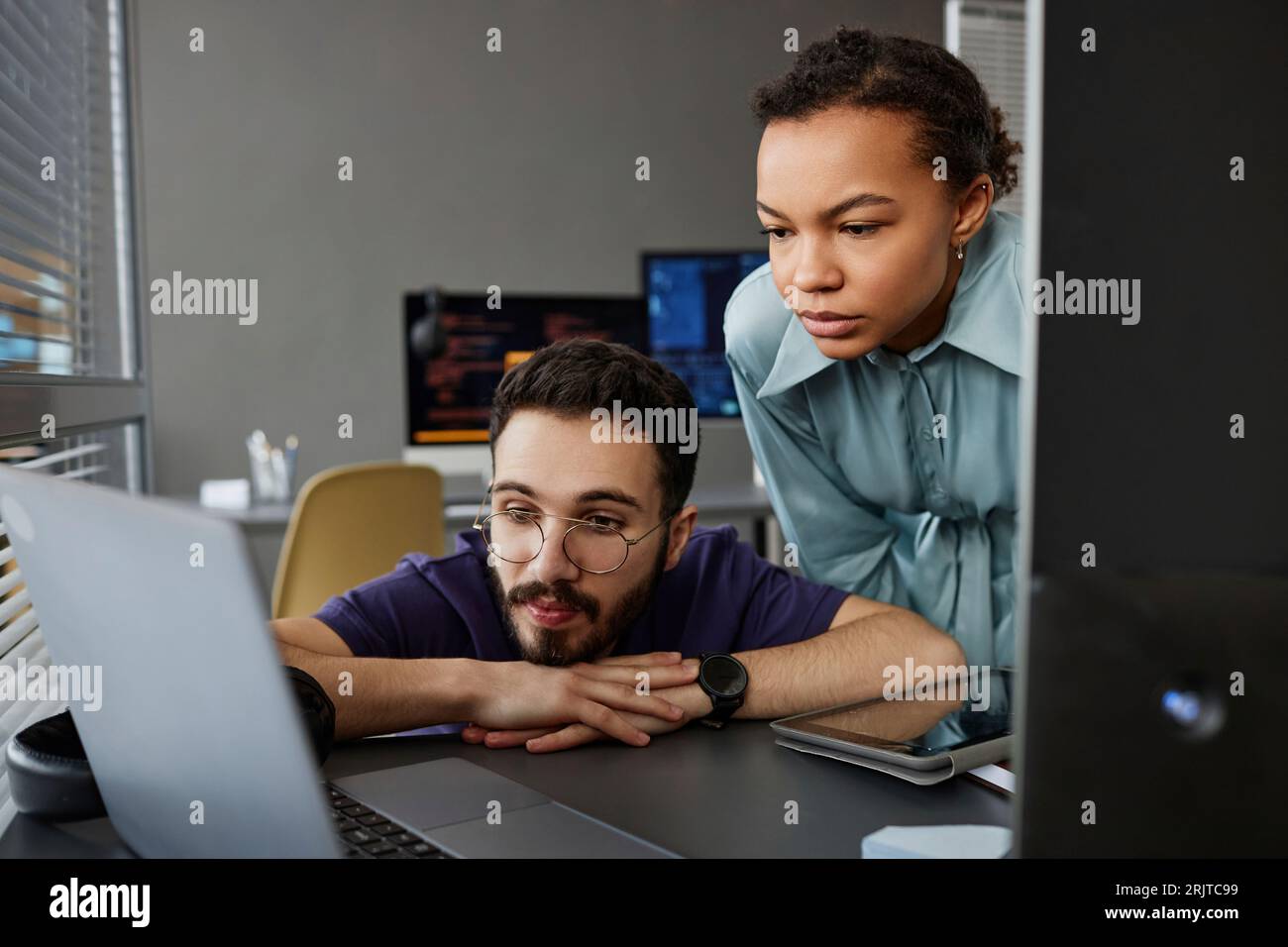 IT-Profis arbeiten am Schreibtisch gemeinsam an Notebooks Stockfoto