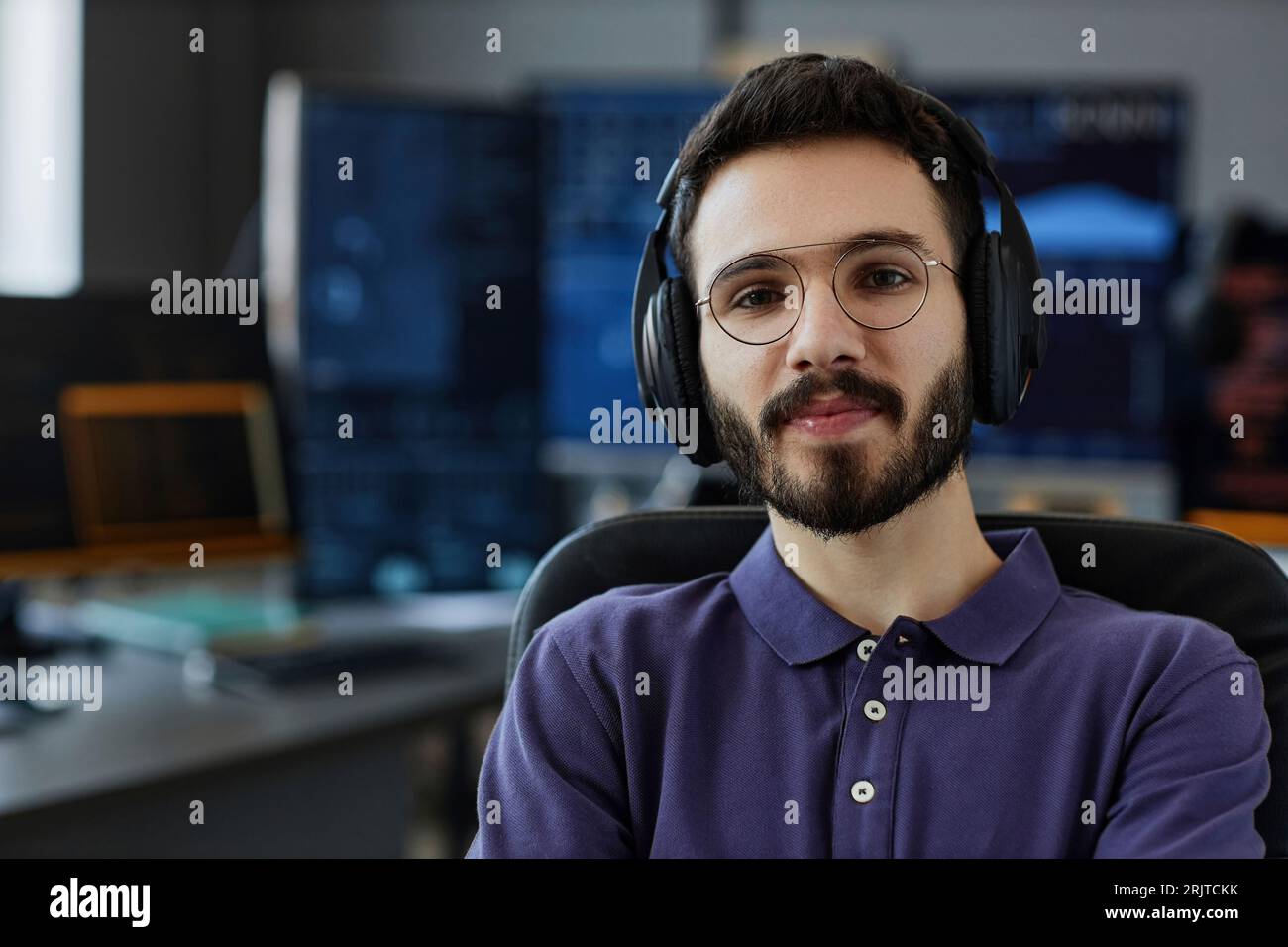 Lächelnd und professionell mit kabellosen Kopfhörern und Brillen im Büro Stockfoto
