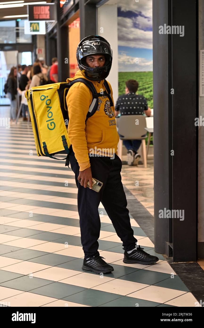 Glovo Food Delivery Motorradfahrer wartet auf die Abholung von Lebensmitteln Bestellung vor Fast Food Service in Fnac Einkaufszentrum, Aveiro, Portugal Stockfoto