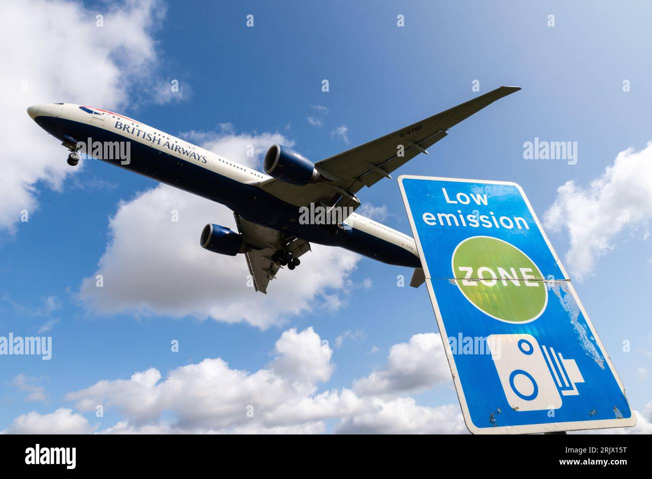 Schild für emissionsarme Zonen mit Landung eines Düsenflugzeugs am Flughafen London Heathrow, Großbritannien. Luftverschmutzung. Kohlendioxidemissionen. Luftverkehrsemissionen. Kamerabild Stockfoto