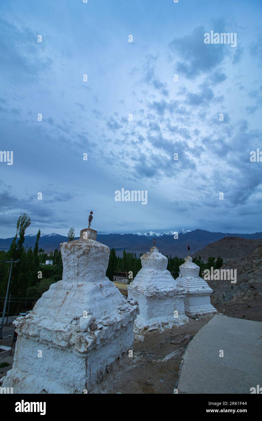 Viele weiße Stupas in einer Reihe auf einem Berg mit blauem Himmel im Hintergrund Stockfoto