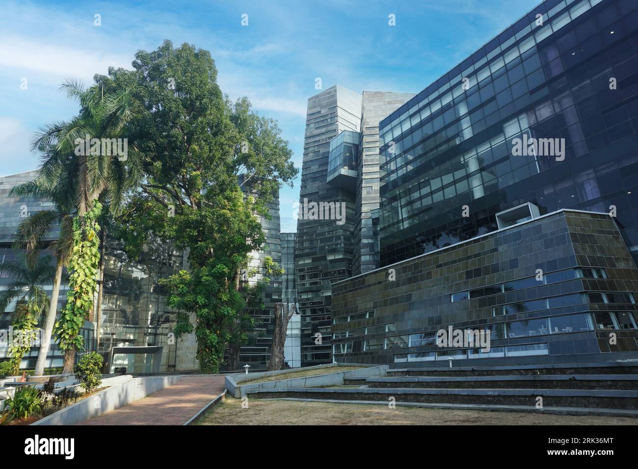 Moderne, umweltfreundliche Glasarchitektur und Grün vor blauem Himmel. Stockfoto
