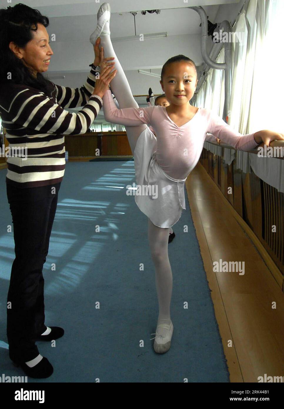 Bildnummer: 53585705 Datum: 18.10.2009 Copyright: imago/Xinhua (091108) -- HARBIN, 8. November 2009 (Xinhua) -- Liang Yuxin (R) tanzt mit ihrer Lehrerin in Harbin, der Hauptstadt der nordöstlichen Provinz Heilongjiang, am 18. Oktober 2009. In einem Märchen tanzt ein hübsches Mädchen mit ihren roten Schuhen, so dass ihre Schuhe mit ihren Füßen zusammenwachsen. Das 10-jährige Mädchen Liang Yuxin tanzt genauso gerne wie das Mädchen im Märchen. Liangs Eltern sind Bauern in der Provinz Heilongjiang. Wie die Kinder der meisten Wanderarbeiter wurde sie von der Farm ihrer Heimatstadt nach Harbin gebracht Stockfoto
