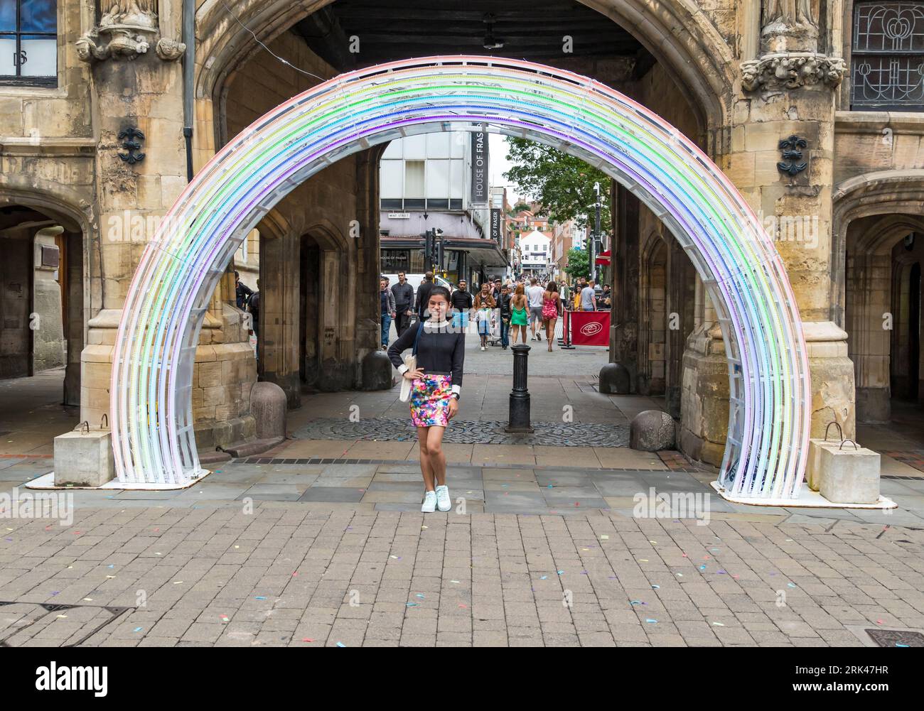 Junge Dame, die in Rainbow Arch in Stonebow steht, um Fotos zu machen, High Street, Lincoln City, Lincolnshire, England, UK Stockfoto