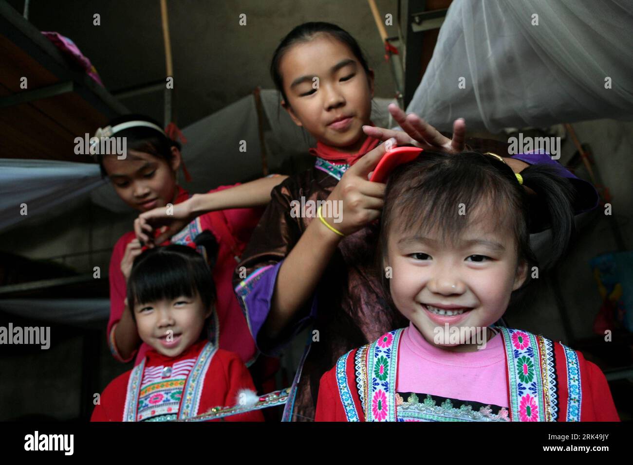 Bildnummer: 53602446 Datum: 16.10.2009 Copyright: imago/Xinhua (091117) -- RONGSHUI, 17. November 2009 (Xinhua) -- Liang Huan (2., R), ein 11-jähriges Mädchen, kämmt Haare für ihre kleine Cousine Schwester Liang Shali in ihrem Internat in der Hope Primary School des Dorfes Sihe in der Gemeinde Sirong, Rongshui Miao Autonomous County, südwestchinesische autonome Region Guangxi Zhuang, 30. Oktober 2009. Es gibt insgesamt 12 Naturgemeinschaften, die sich sporadisch tief in den Bergregionen des Dorfes Sihe verstreut haben, und fast alle Kinder müssen die Sole Hope Primary School besuchen, die sich an einem Ort befindet Stockfoto