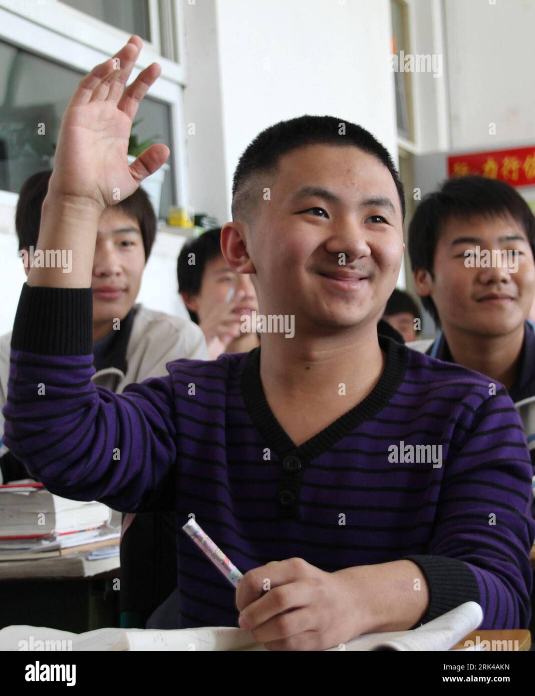 Bildnummer: 53605392 Datum: 01.11.2009 Copyright: imago/Xinhua (091118) -- CHIFENG, 18. Nov. 2009 (Xinhua) -- Lu Jingxuan, ein 13-jähriger behinderter Schüler, der an angeborener brüchiger Knochenerkrankung leidet, einer knochenbildenden Hypogenese von Geburt an, die als Glasperson für Frakturen bezeichnet wird, bringt die Hand, um die Frage des Lehrers im Unterricht zu beantworten, in der Yingcai-Schule in Chifeng City, Nordchinas Autonome Region Innere Mongolei, 1. November 2009. (Xinhua/Li Fu) (FOCUS)(UNIVERSAL CHILDREN S DAY)(6)CHINA-INNER MONGOLIA-GO-MASTER DREAM-BRITTLE BONE DISEASE(CN) PUBLICATIONxNOTxINxCHN China G Stockfoto