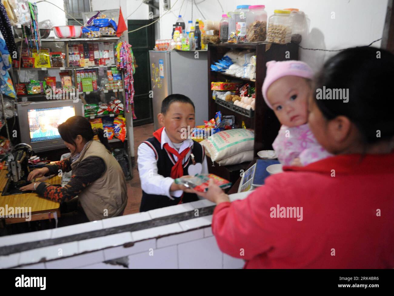 Bildnummer: 53611723 Datum: 06.11.2009 Copyright: imago/Xinhua (091119) -- CHENGDU, 19. November 2009 (Xinhua) -- Xu Zhongzheng hilft seiner Mutter in ihrem Lebensmittelgeschäft in der Stadt Dujiangyan in Chengdu, der Hauptstadt der südwestchinesischen Provinz Sichuan, am 11. November 2009. Der zehnjährige Xu Zhongzheng ist ein Schüler der fünften Klasse in der Neuen Grundschule der Stadt Dujiangyan in Chengdu. Als das katastrophale Erdbeben vom 12. Mai ausbrach, wurden Xu und seine Mitschüler unter den Ruinen begraben. In diesem kritischen Moment hob er sich hervor und sang laut die Nationalhymne, um andere zu ermutigen. Dank seines Gesangs, seiner Lehrer und seiner Klas Stockfoto