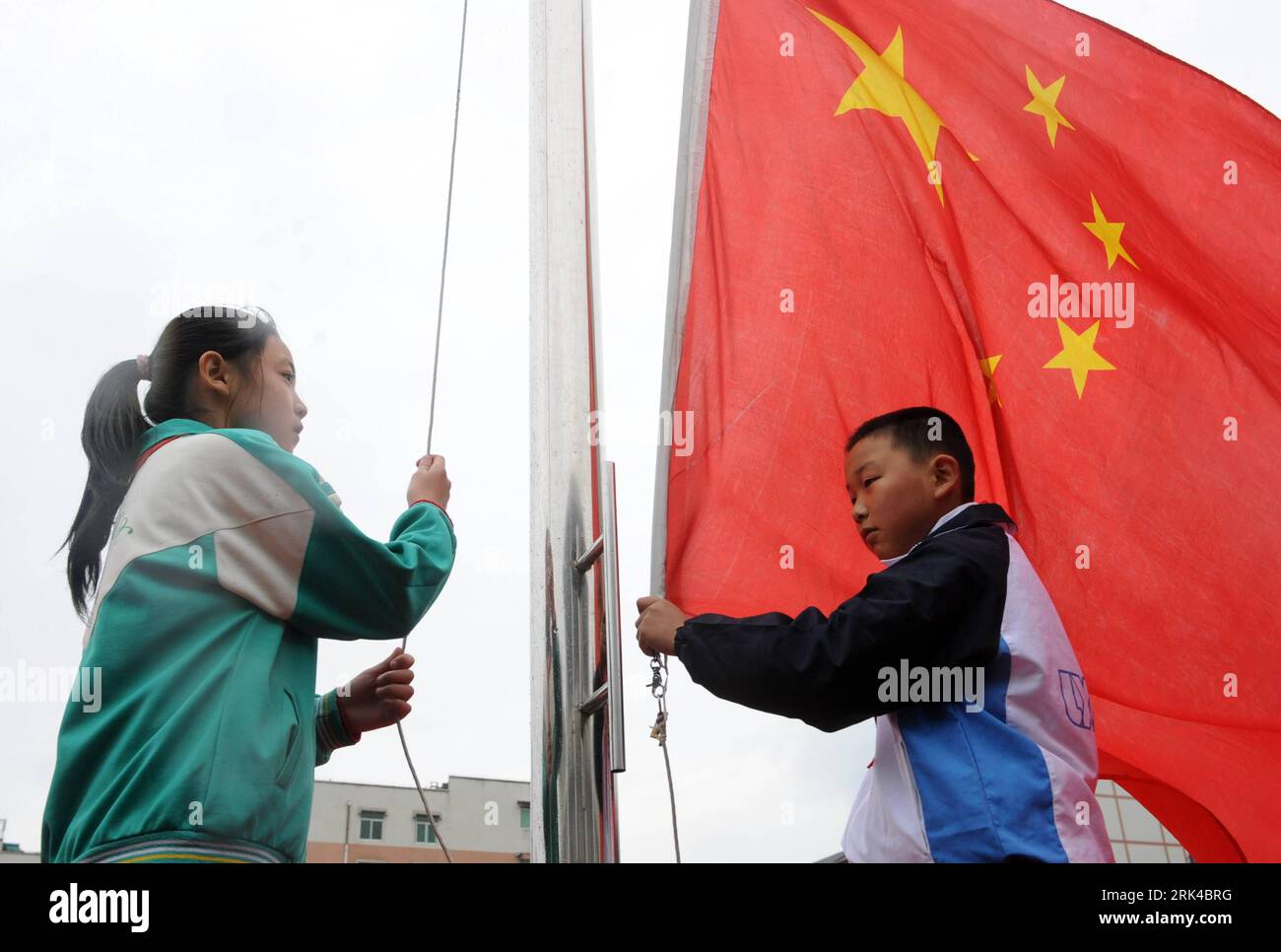 Bildnummer: 53611724 Datum: 06.11.2009 Copyright: imago/Xinhua (091119) -- CHENGDU, 19. November 2009 (Xinhua) -- Xu Zhongzheng hisst die Nationalflagge in der Neuen Grundschule der Stadt Dujiangyan, Chengdu, Hauptstadt der südwestchinesischen Provinz Sichuan, 12. November 2009. Der zehnjährige Xu Zhongzheng ist ein Schüler der fünften Klasse in der Neuen Grundschule der Stadt Dujiangyan in Chengdu. Als das katastrophale Erdbeben vom 12. Mai ausbrach, wurden Xu und seine Mitschüler unter den Ruinen begraben. In diesem kritischen Moment hob er sich hervor und sang laut die Nationalhymne, um andere zu ermutigen. Dank seines Singens, Tee Stockfoto