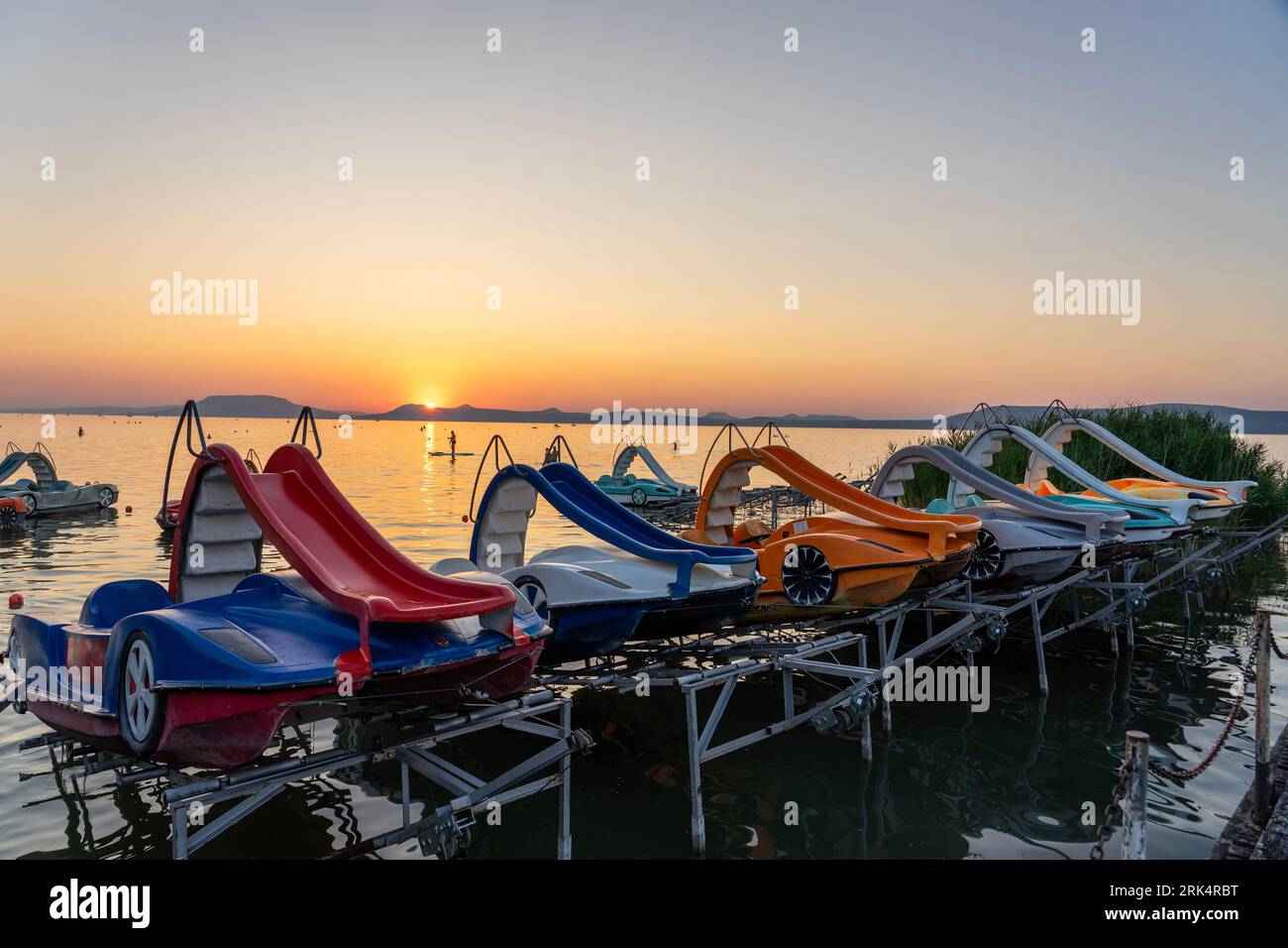 colorful paddle boats funny activity in the sunset with a slide on the lake Balaton in Hungary Stockfoto