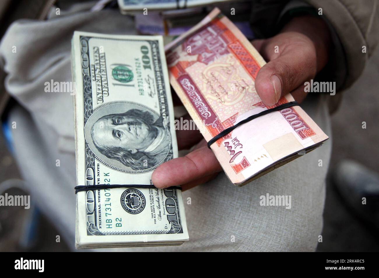 Bildnummer: 53661581 Datum: 12.12.2009 Copyright: imago/Xinhua (091212) -- KABUL, 12. Dezember 2009 (Xinhua) -- ein afghanischer Händler hält am 12. Dezember 2009 US-Dollar-Banknoten und afghanische Banknoten an einem Devisenmarkt in Kabul, der Hauptstadt Afghanistans. Vor kurzem fand ein Seminar statt, um zu erörtern, wie verhindert werden kann, dass US-Dollar illegal aus Afghanistan ausgezogen werden. (Xinhua/Zabi Tamanna) (lr) AFGHANISTAN-KABUL-USA DOLLAR-ILLEGAL TRANSFER-CURB PUBLICATIONxNOTxINxCHN Geldwechsel Geld Währung wechselt Wechsel kbdig xng 2009 quer Premiumd o0 Schein Geldschein Körperteile Hand o Stockfoto