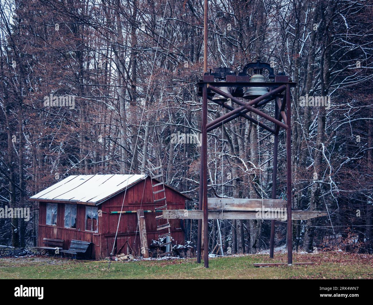 Eine isolierte alte Hütte in einem Wald, umgeben von einem rustikalen Holzzaun Stockfoto