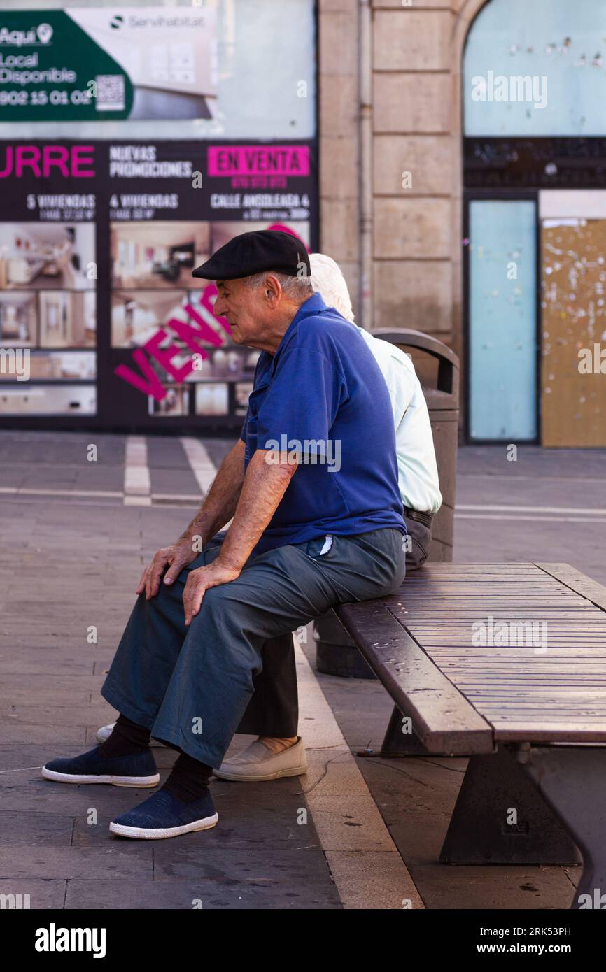 Pamplona, Spanien - Juli 31: Ein alter Mann mit blauem Hemd sitzt auf einer Bank in den Straßen von Pamplona Stockfoto