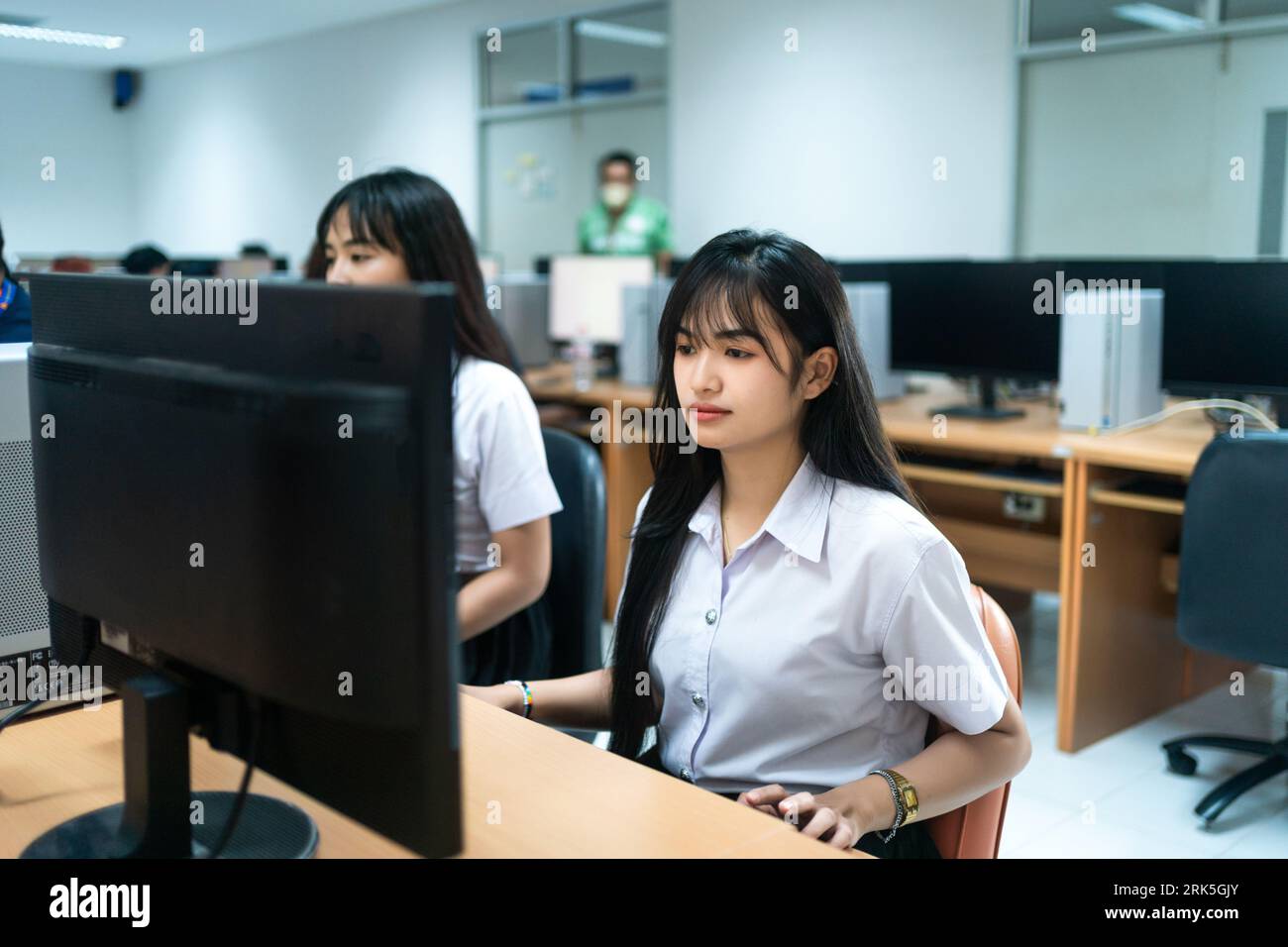 Eine asiatische Studentin arbeitet an einem Laptop in einem Arbeitszimmer Stockfoto
