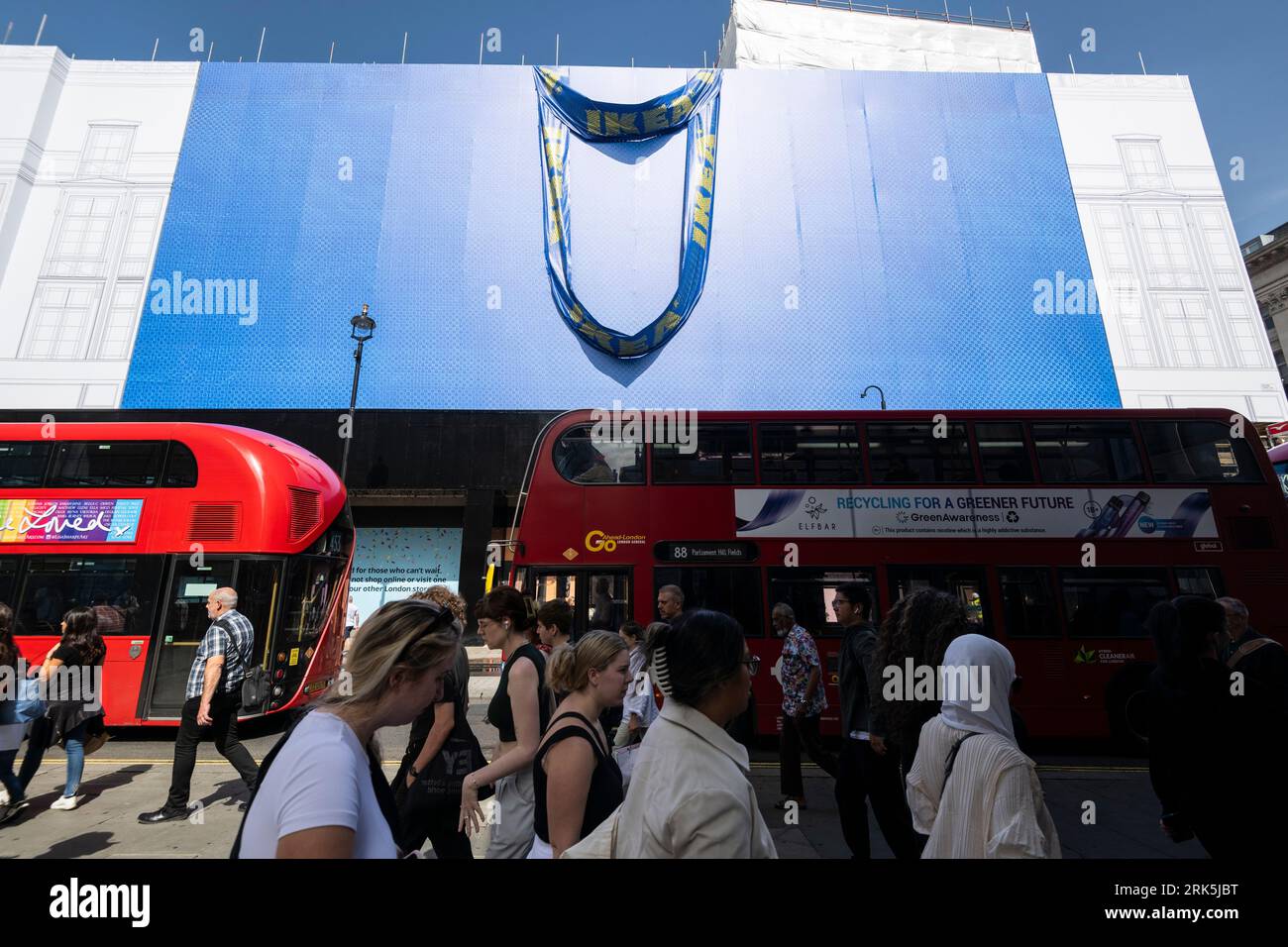 London, Großbritannien. 24. August 2023. Die Leute passieren eine riesige IKEA-Einkaufstasche, die auf der Außenanlage des ehemaligen Top Shop-Flaggschiffs im Oxford Circus enthüllt wurde. IKEA plant, im Herbst 2024 (früher für Herbst 2023 geplant) an diesem Standort ein innerstädtisches Geschäft zu eröffnen. Kommentatoren haben gesagt, dass die Oxford Street, einst Europas belebteste Einkaufsstraße, dringend einen Impuls braucht. Quelle: Stephen Chung / Alamy Live News Stockfoto