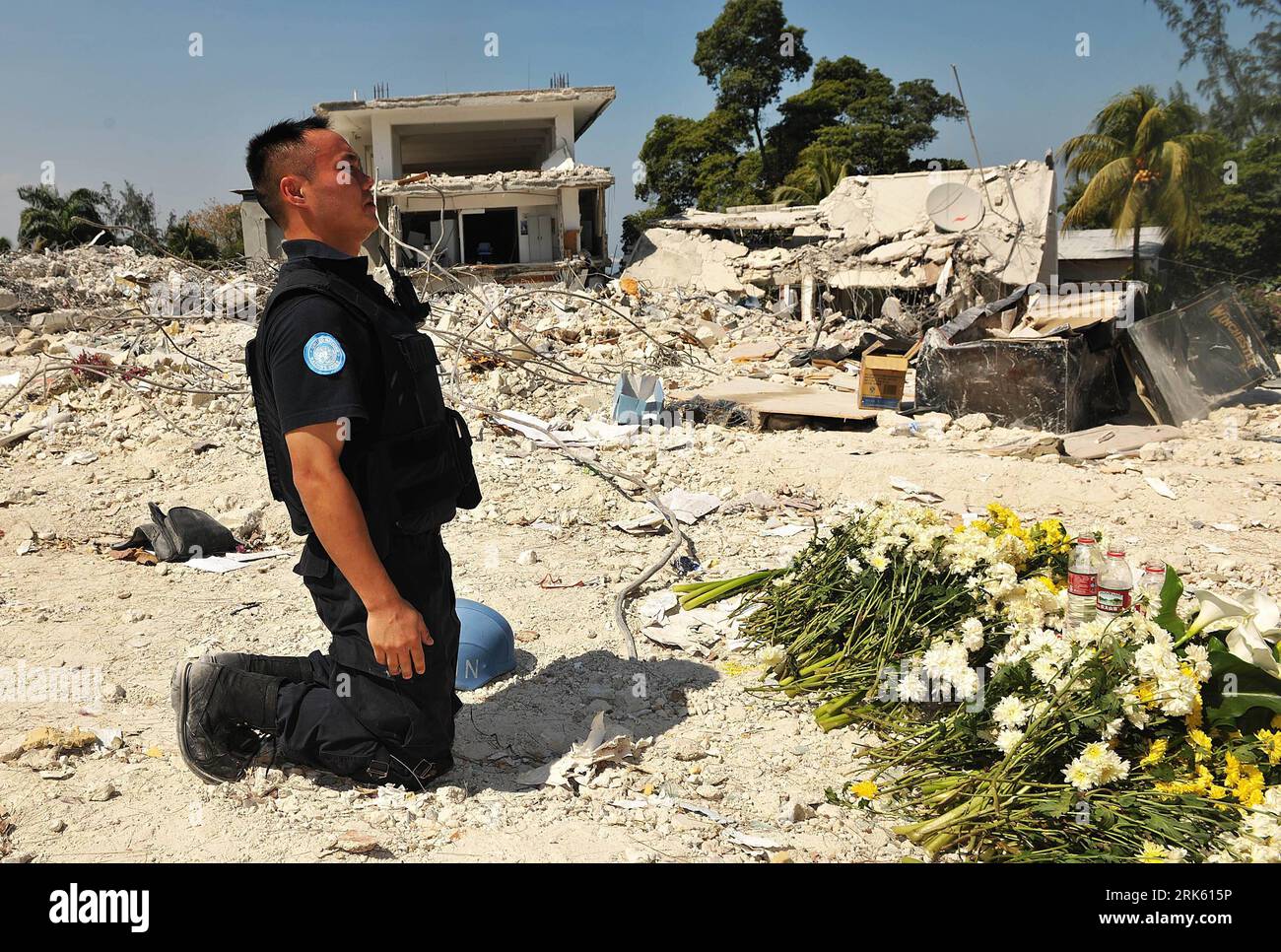 Ein Mitarbeiter der chinesischen Polizei mit der Stabilisierungsmission der Vereinten Nationen in Haiti (MINUSTAH) widmet den Märtyrern in Port-au-Prince am 5. Februar 2010 Blumen. Die Mitarbeiter der chinesischen Polizei mit der MINUSTAH und das chinesische medizinische Team, das Haiti unterstützt, hielten eine Zeremonie ab, um acht Mitglieder der chinesischen Polizei zu gedenken, die bei dem Erdbeben in Haiti ihr Leben verloren. (Xinhua/Wu Xiaoling) (wh) (3)HAITI-ERDBEBEN-CHINESISCHE MITARBEITER-GEDENKTAGE PUBLICATIONxNOTxINxCHN Stockfoto