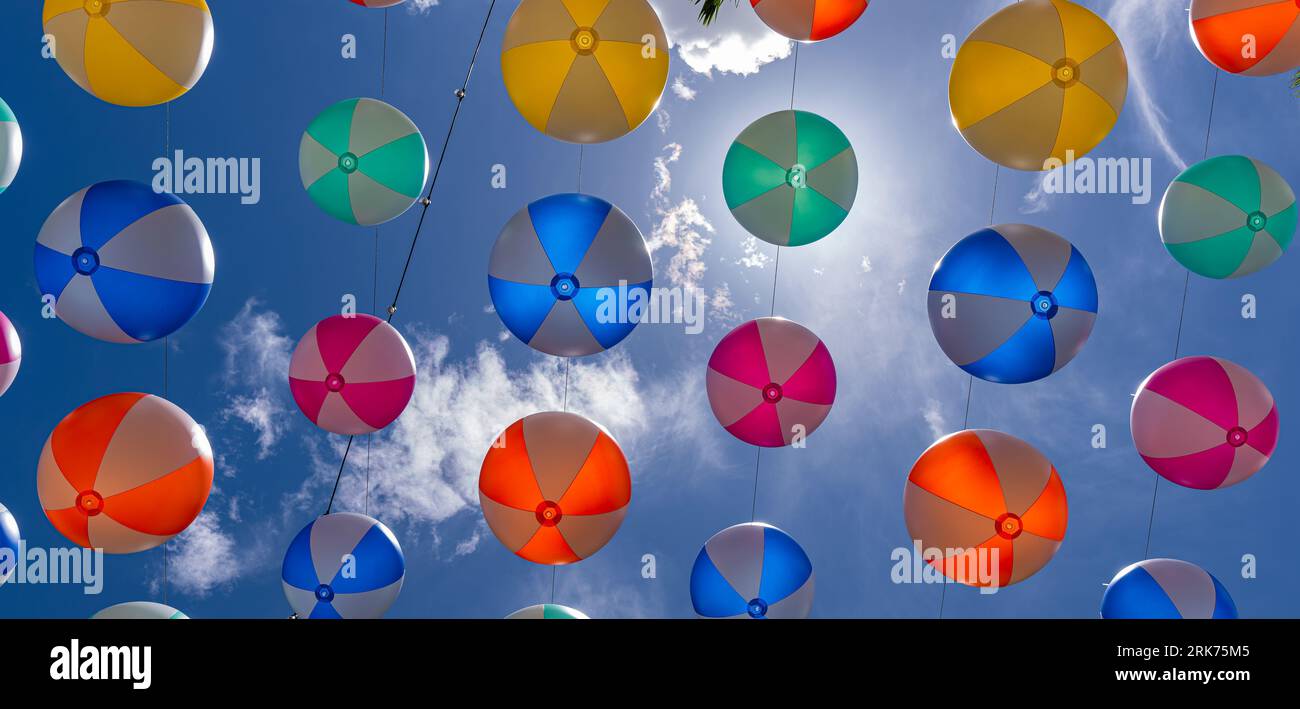 Ein Bild eines lebendigen Himmels gefüllt mit einer Mischung aus bunten Bällen vor dem Hintergrund eines tiefen blauen Himmels und weißer, wolowy Wolke Stockfoto