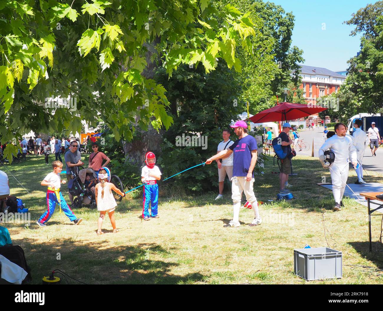 Eine vielfältige Gruppe von Menschen, die eine fröhliche Zeit in einem üppigen grünen Park in Darmstadt verbringen Stockfoto