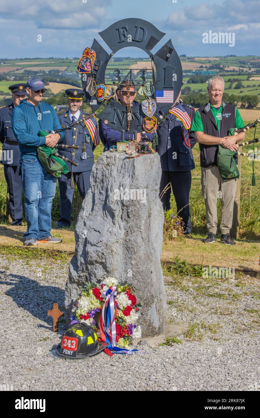 New York Firefighters und die Emerald Pipe und Drums besuchen den Gedenkgarten für gefallene Feuerwehrleute von 9/11 in Ringfinnan, Kinsale Co Cork, Irland. Stockfoto
