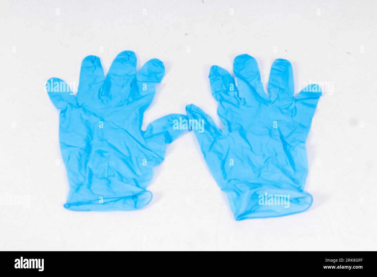 Blaue Handschuhe für den Gesundheitsschutz isoliert auf weißem Hintergrund. Medizinische Nitrilhandschuhe. Herstellung von Gummihandschuhen, Latexhandschuhen. Schutzhandschuhe Stockfoto
