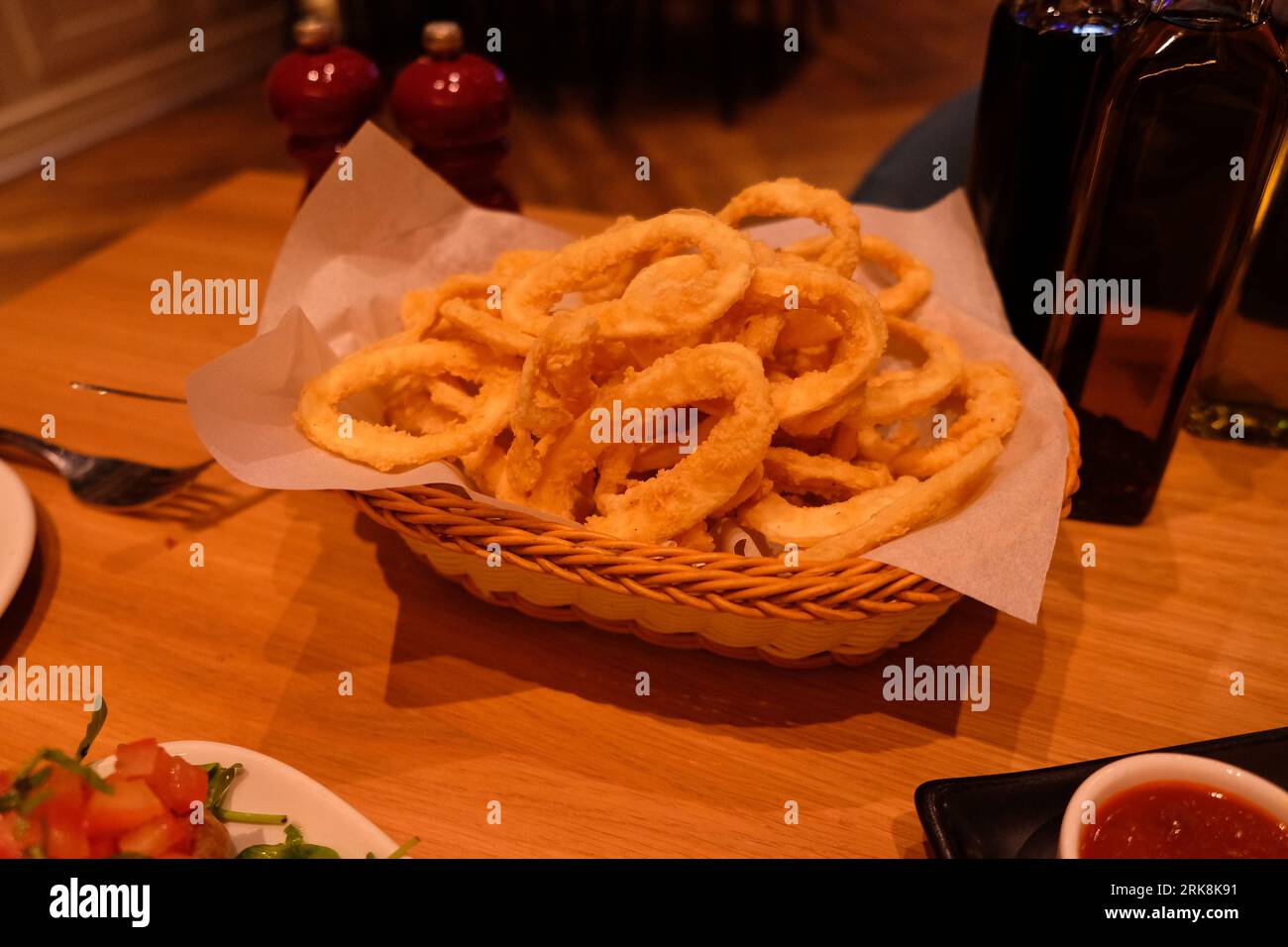 Ein Korb mit Crunchy Calamari, der den Tisch vereinigt Stockfoto