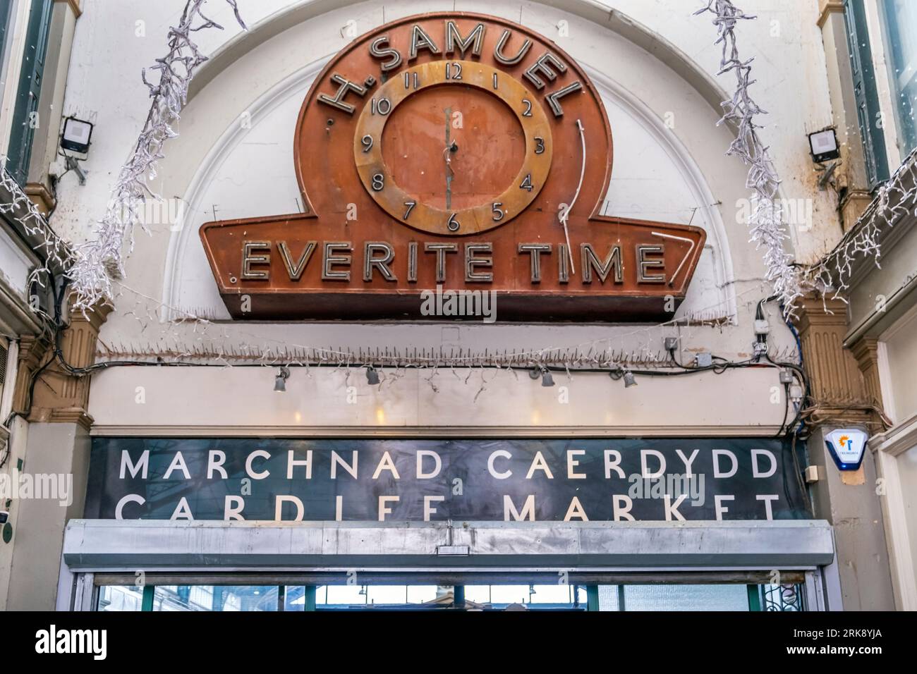 Alte Uhr über dem Eingang zum viktorianischen Cardiff Market, ein denkmalgeschütztes Gebäude der 2. Klasse im Castle Quarter der Stadt Cardiff, Wales Stockfoto