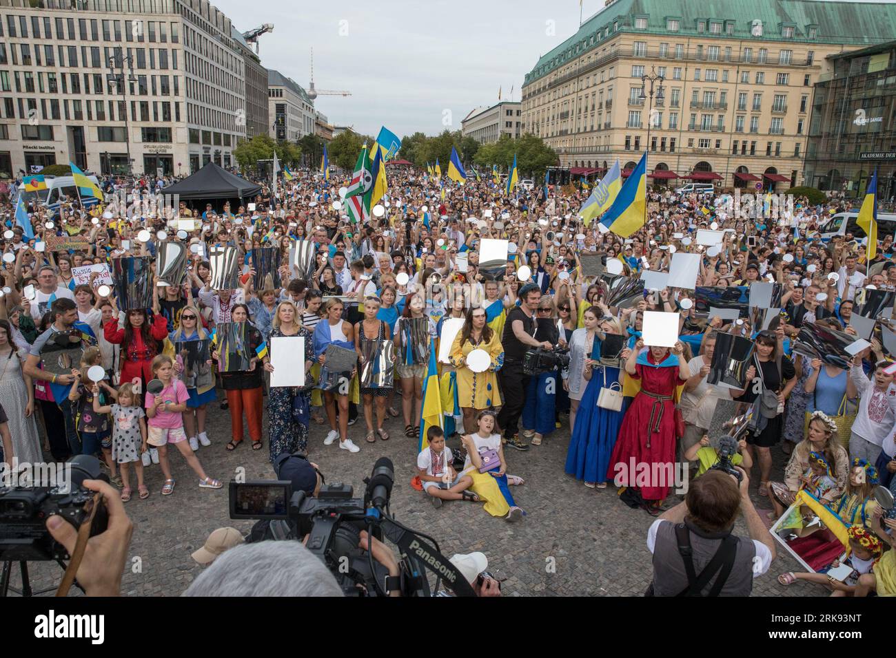 Berlin, Deutschland. August 2023. Am 24. August 2023 versammelten sich Ukrainer am Brandenburger Tor in Berlin, um den Unabhängigkeitstag der Ukraine zu begehen. Aber das war keine gewöhnliche Feier. Die Menge, ein Meer von Sonnenblumen, Fahnen, Fahnen und traditioneller ukrainischer Kleidung, kam mit einer Botschaft der Erinnerung und Belastbarkeit. In einer symbolischen Geste hielten die Teilnehmer Spiegel hoch, insgesamt 503, die jeweils das Gesicht eines Kindes widerspiegeln, das im russischen Krieg gegen die Ukraine verloren ging. Die Spiegel funkelten unter der untergehenden Sonne und dienten als eindringliche Erinnerung an die 503 ukrainischen Kinder, deren Leben abrupt und rücksichtslos war Stockfoto