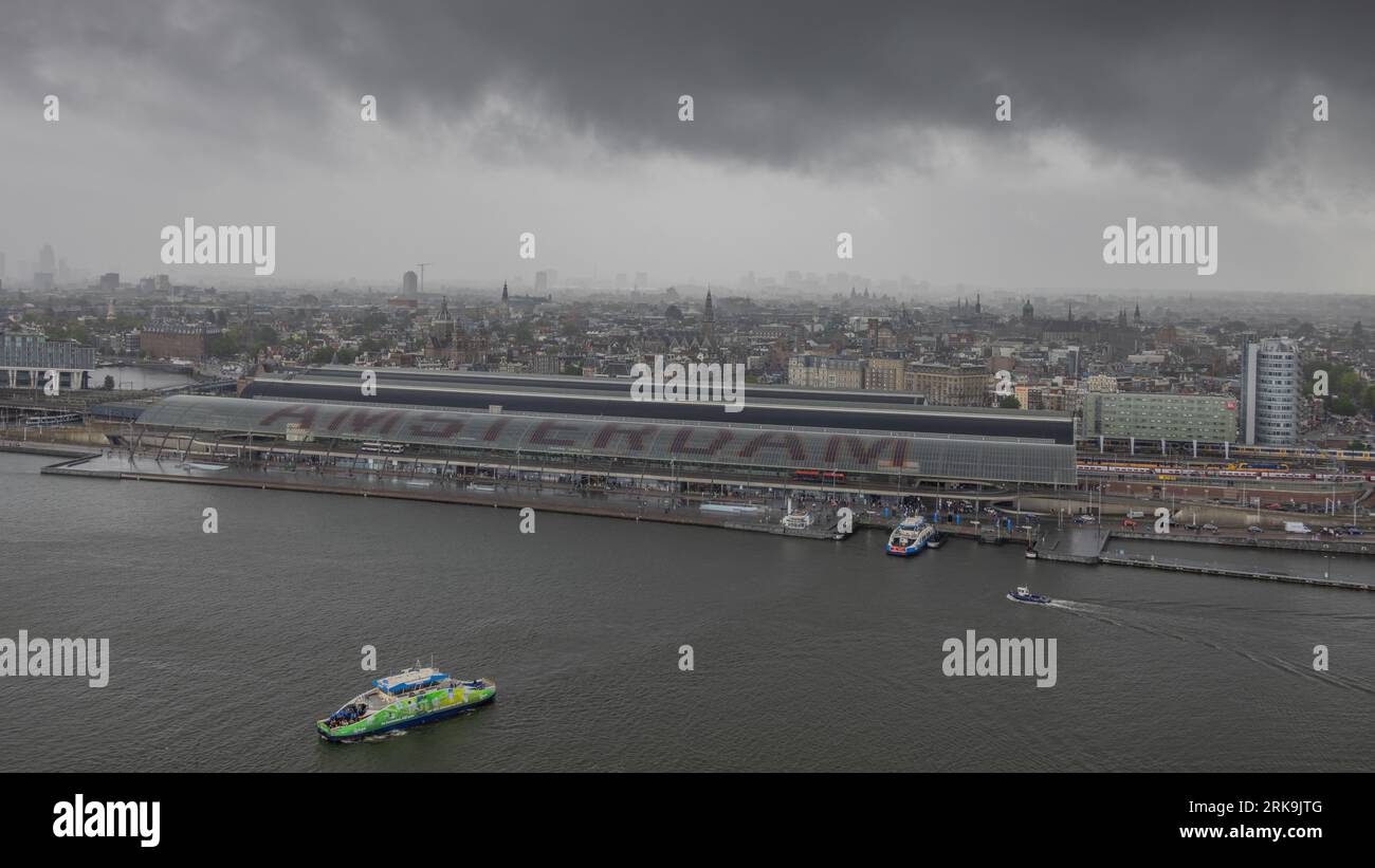 Amsterdamer Hauptbahnhof neben den Stadtkanal in Amsterdam, Niederlande, ein wichtiger Knotenpunkt für niederländische und internationale Züge. Stockfoto
