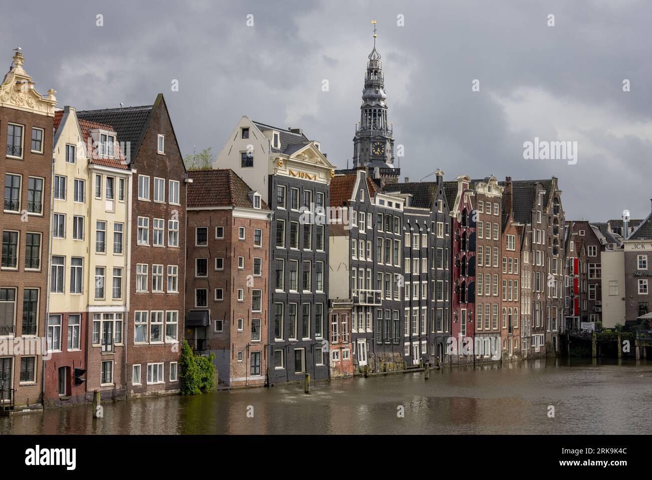 Stadtgebäude von Amsterdam neben den Kanälen in den Niederlanden mit farbenfrohen Fassaden, historischen Giebeln und klassischen holländischen Stadthäusern. Stockfoto