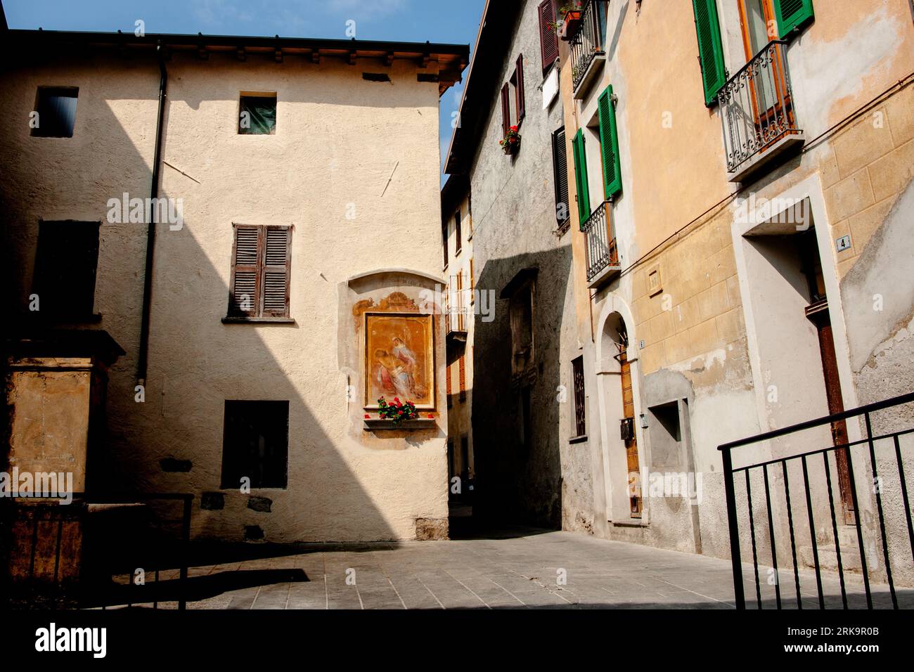 Cima Italien - 5. Mai 2011; religiöse Nische beleuchtet zwischen baulichen Schatten im Innenhof in Italien am Ufer des Luganer Sees. Stockfoto