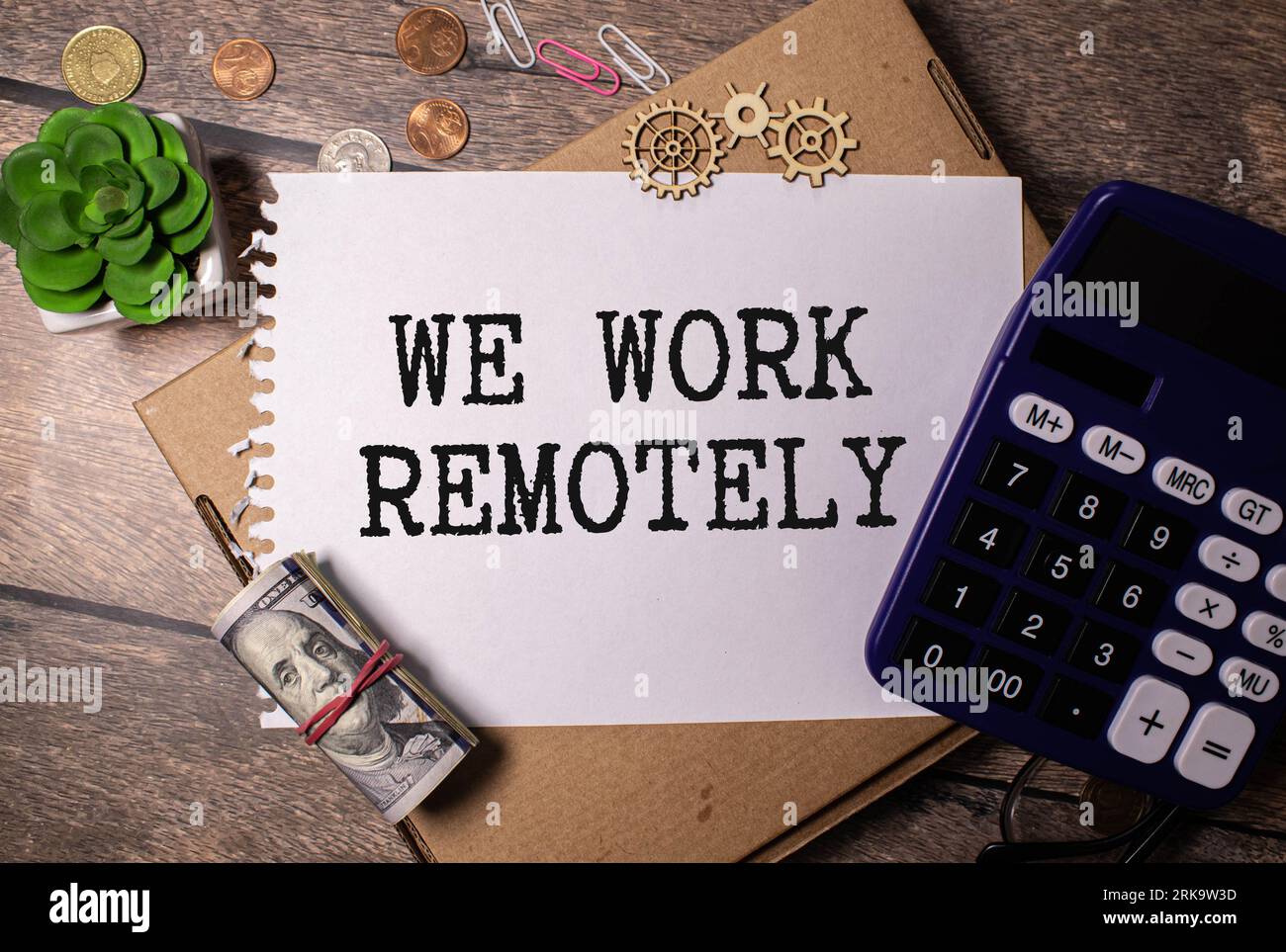 WORK REMOTELY text on a sticky with pen on the wooden background. Stockfoto