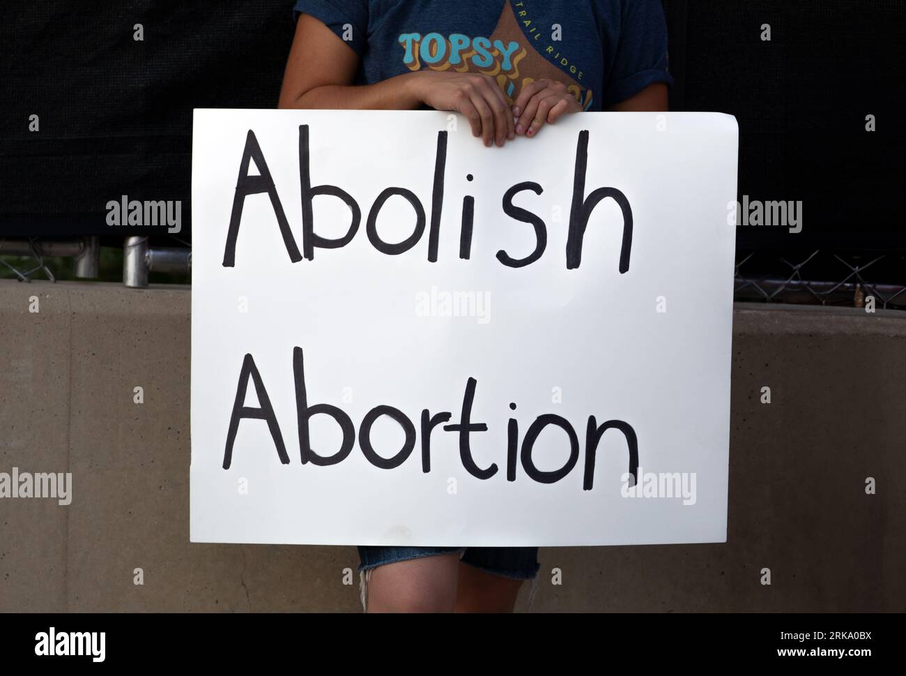 Milwaukee, Wisconsin, USA - 23. August 2023: Ein Demonstrant hält ein Protestschild gegen Abtreibung am Eingang der ersten Debatte des republikanischen Präsidenten 2024. Stockfoto