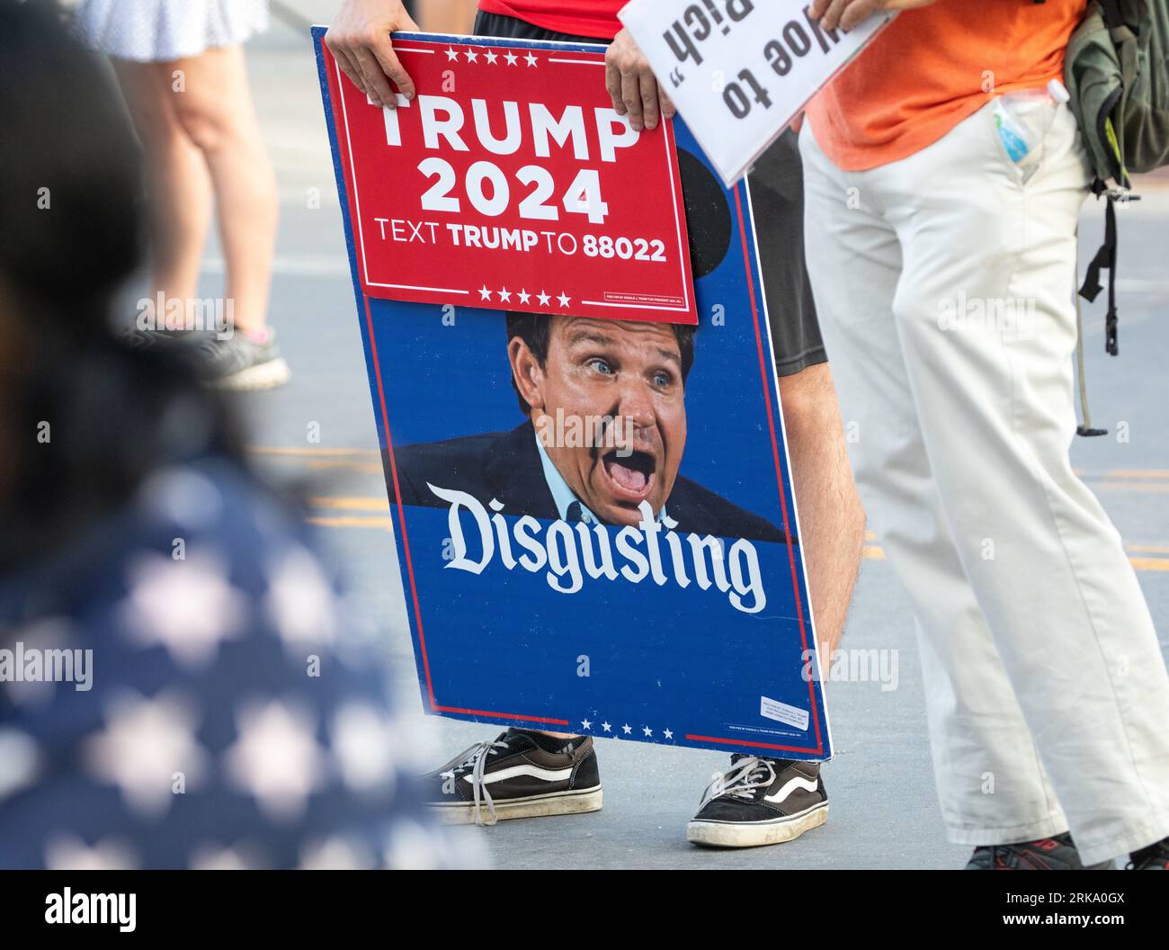 Milwaukee, Wisconsin, USA - 23. August 2023: Ein Unterstützer von Präsident Joe Biden hält ein Protestzeichen gegen den Gouverneur von Florida, Ron Desantis, am Eingang zur ersten Debatte über den republikanischen Präsidenten 2024. Stockfoto