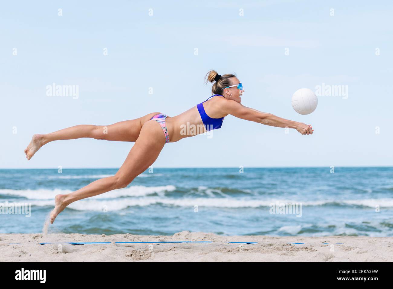 Professionelle Spielerin, die am Strand Volleyball spielt. Horizontales Sportposter, Grußkarten, Kopfzeilen, Website und App Stockfoto