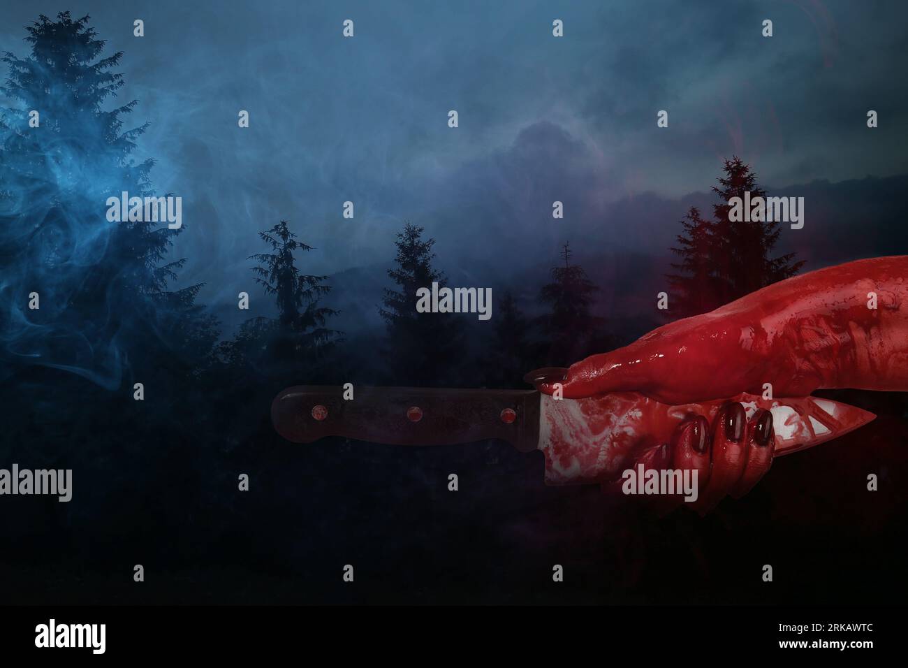 Hand with bloodstained knife in dark forest Stockfoto