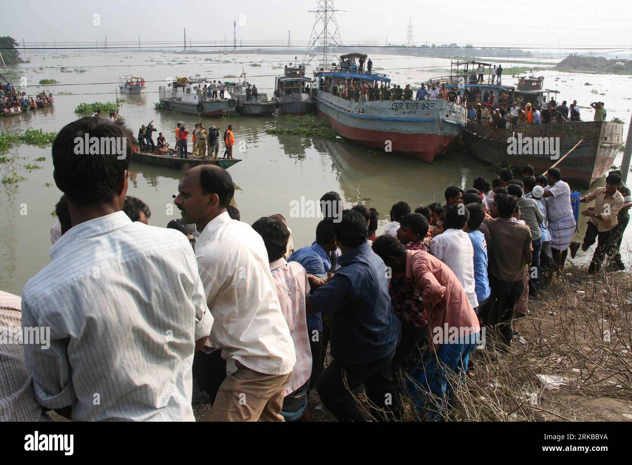 Bildnummer: 54530850 Datum: 12.10.2010 Copyright: imago/Xinhua (101012) -- DHAKA, 12. Oktober 2010 (Xinhua) -- Lokale halten das Seil, um das Frachtschiff stabil genug zu machen, um den versunkenen Bus aus dem Fluss in Savar, den Vororten von Dhaka, der Hauptstadt von Bangladesch, am 12. Oktober 2010 zu ziehen. Am Dienstagnachmittag brachten die Rettungskräfte schließlich den versunkenen Bus zwei Tage nach dem Sturz in den Turag auf das Flussufer. Mehr als zehn Menschen starben während des Unfalls und mehrere weitere sind noch immer verschwunden. (Xinhua/Shariful Islam) BANGLADESCH-DHAKA-VERSUNKENER BUS PUBLICATIONxNOTxINxCHN Gesellschaft Verkehr Strasse Bus Stockfoto