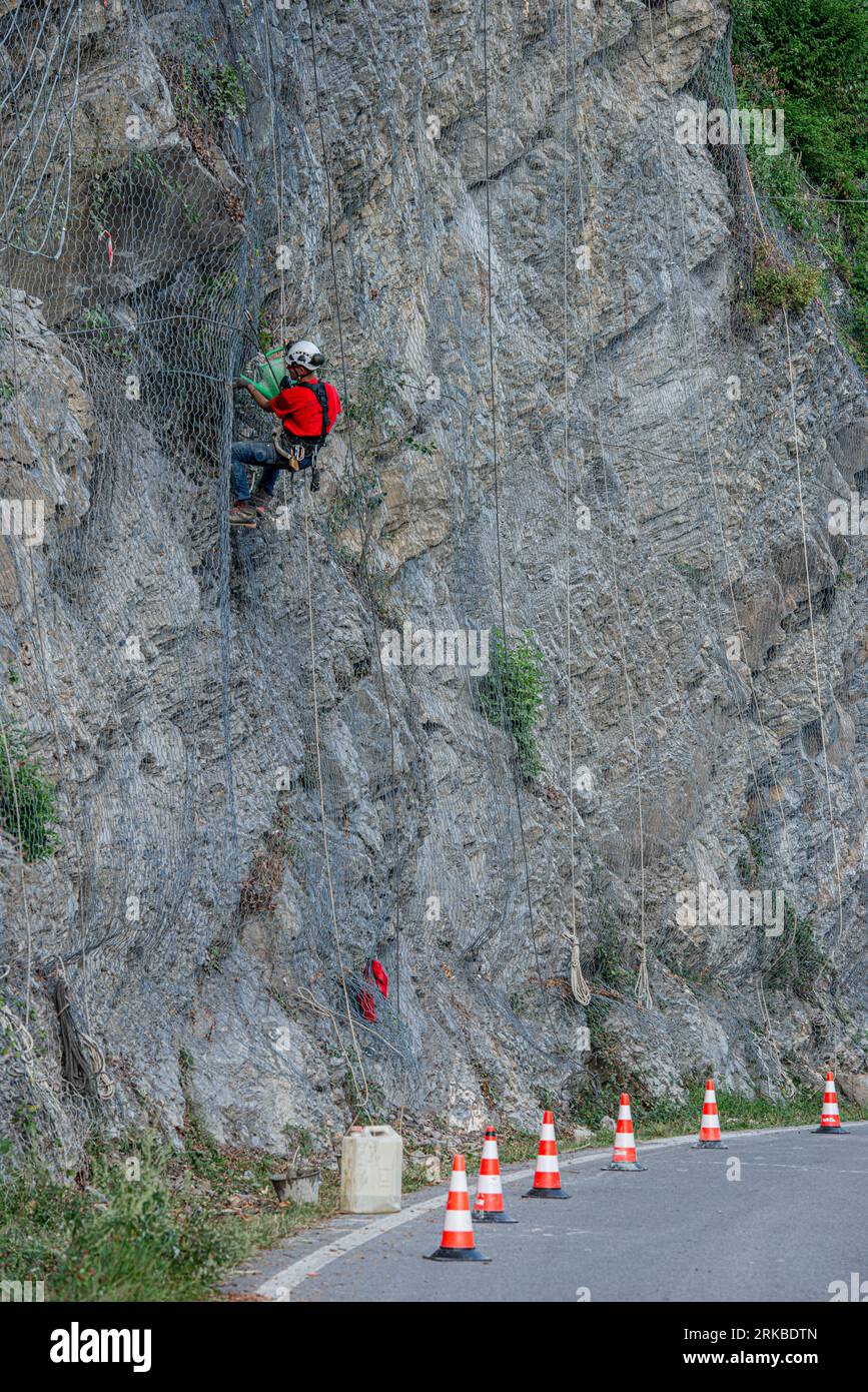 Dossena Italy 24. August 2023: Kletterer platzieren Sicherheitsnetze, um herabfallende Felsen zu vermeiden Stockfoto