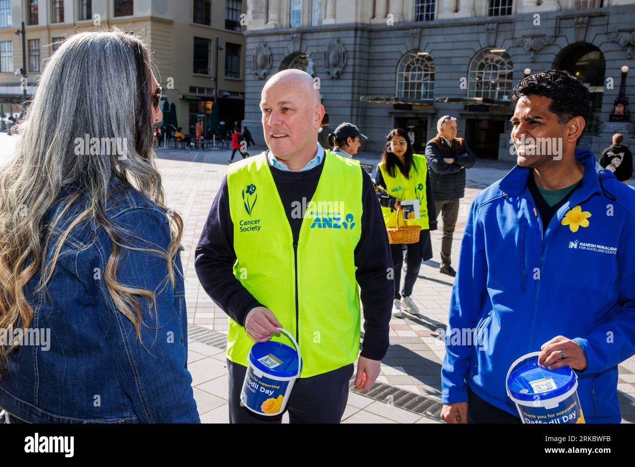Auckland, Neuseeland, 25. August 2023. Der nationale Parteichef Christopher Luxon (C) und Mahesh Muralidhar, ein Kandidat der Auckland Central, sammeln sich für den Daffodil Day der Cancer Society, während er sich für die Wahlen einsetzt. Quelle: David Rowland/Alamy Live News Stockfoto