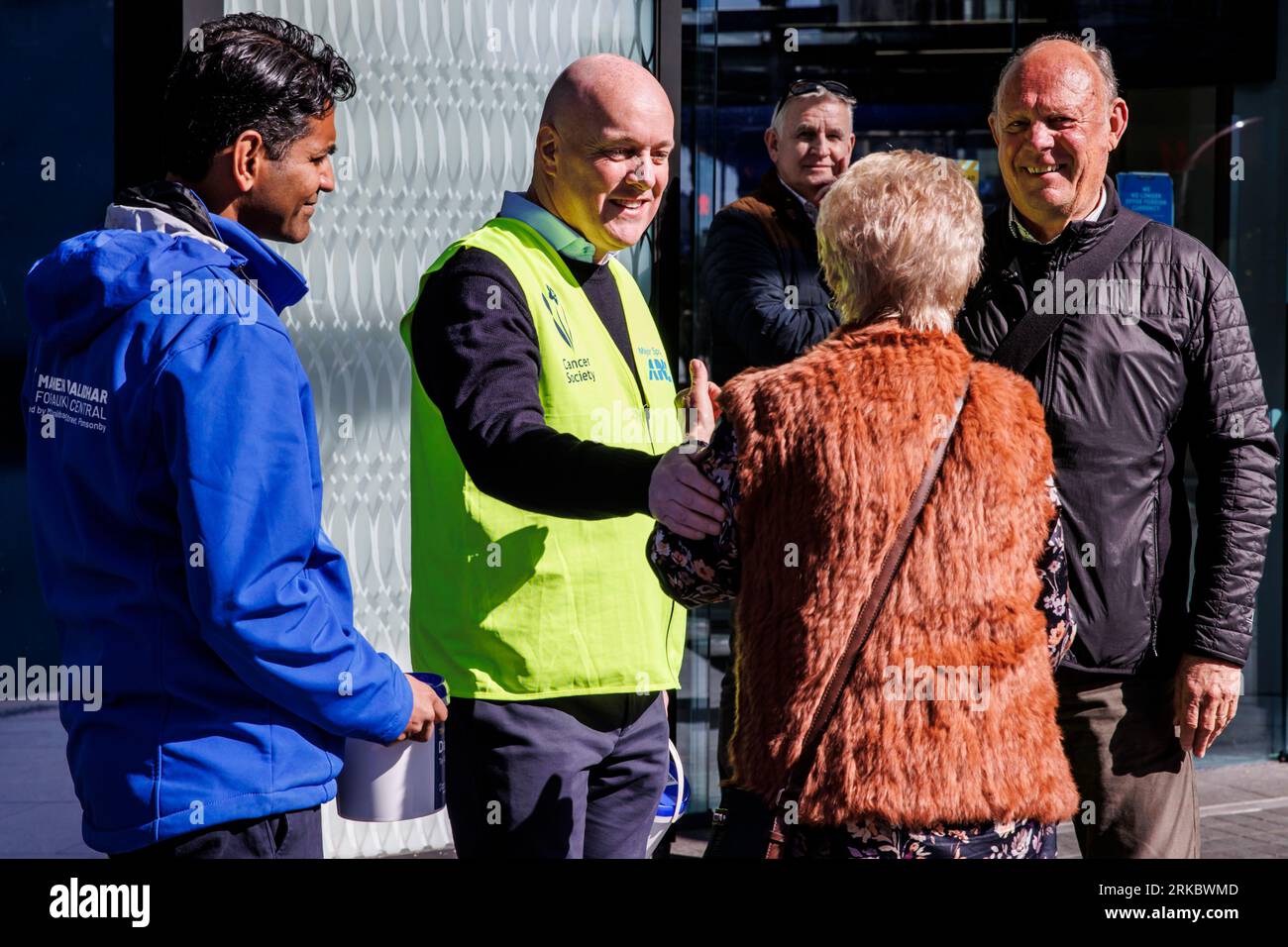 Auckland, Neuseeland, 25. August 2023. Der Parteivorsitzende Christopher Luxon (C) und Mahesh Muralidhar (L) aus Auckland Central sammeln sich für den Daffodil Day der Cancer Society, während er für die Wahlen kandidiert. Quelle: David Rowland/Alamy Live News Stockfoto
