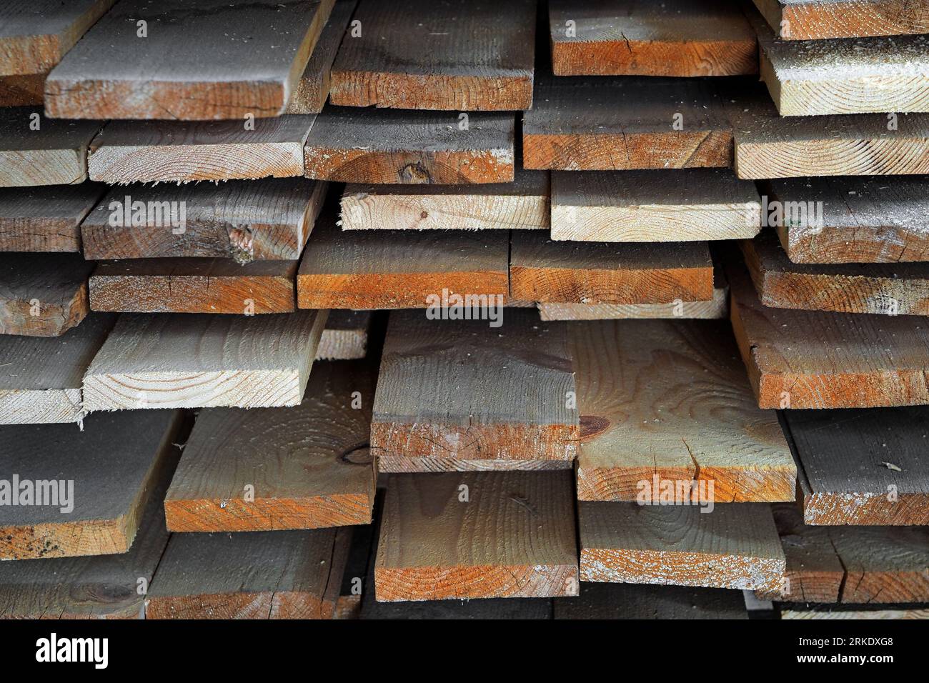 Neue gehobelte Holzbretter im Sägewerk gestapelt. Beschaffung und Verkauf von Baumaterial. Trockenes Holz. Holzbearbeitung. Hintergrund. Stockfoto