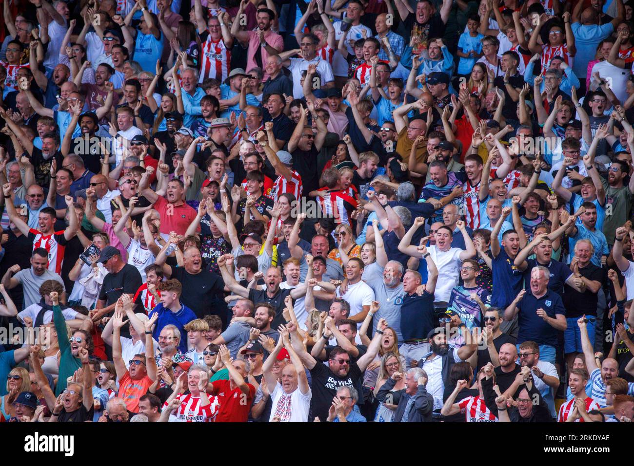 Fußballfans aus Brentford feiern in Craven Cottage, als Brentford Fulham mit 3:0 besiegte. Stockfoto