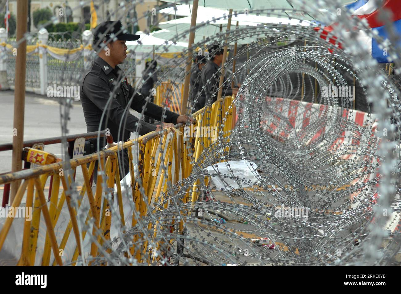 Bildnummer: 55029706 Datum: 15.03.2011 Copyright: imago/Xinhua (110315) -- BANGKOK, 15. März 2011 (Xinhua) -- thailändische Polizeiwache neben Stacheldraht in der Nähe des Ortes der Kundgebung in Bangkok, Hauptstadt von Thailand, 15. März 2011. Die Polizei glaubt, dass die Demonstranten der gelb bekleideten Volksallianz für Demokratie (PAD) und des Thai Patriots Network (TPN) am 18. März von den aktuellen Protestseiten umziehen werden oder rechtliche Schritte Unternehmen werden, sagte Wichai Sangprapai, Leiter der Metropolitan Police Division am Dienstag. (Xinhua/achen Sageamsak) (jl) THAILAND-BANGKOK-POLITICS-Protest PUBLICATIONxNOTxINxCHN Gesellschaft Politik Protest Stockfoto