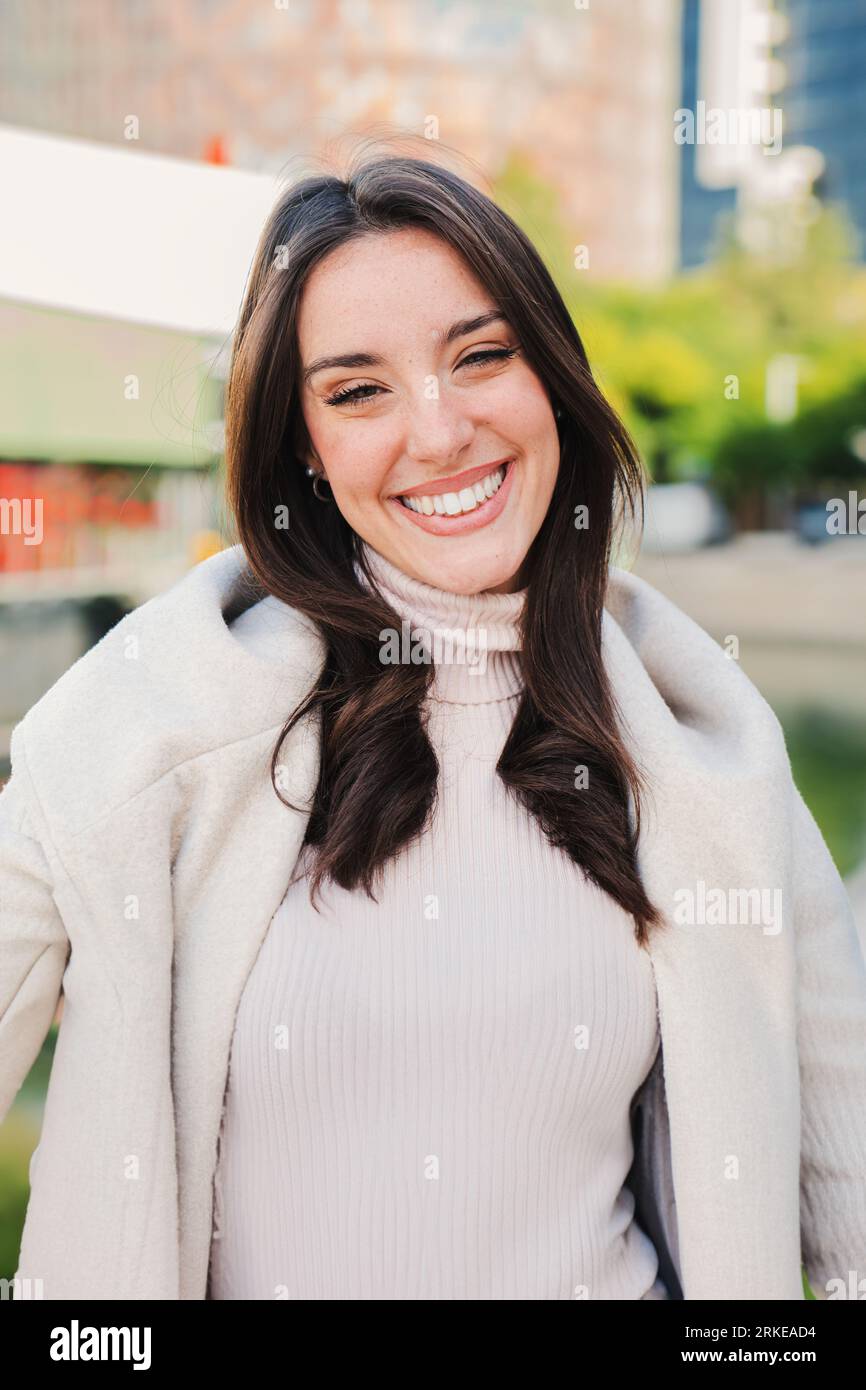 Vertical individual close up portrait of caucasian young woman smiling and looking at camera with perfect white teeth. Beautiful happy female staring front with positive and candid expression. High quality photo Stockfoto