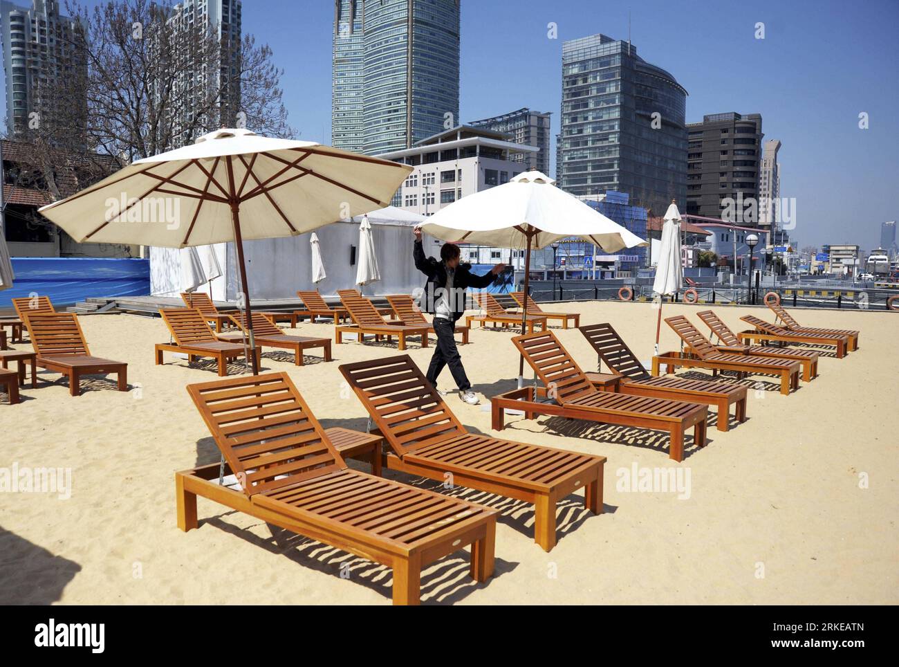 Bildnummer: 55178976 Datum: 31.03.2011 Copyright: imago/Xinhua (110331) -- SHANGHAI, 31. März 2011 Xinhua) -- Ein Mitarbeiter öffnet einen Regenschirm an einem künstlichen Sandstrand in der Nähe des Huangpu-Flusses im ostchinesischen Shanghai, 31. März 2011. Der künstliche Sandstrand wurde als Teil des Projekts zum Wiederaufbau des südlichen Teils des Bundes, Shanghais Wahrzeichen am Wasser, für die Öffentlichkeit zugänglich gemacht. (Xinhua) (lfj) CHINA-SHANGHAI-ARTIFICIAL SAND BEACH (CN) PUBLICATIONxNOTxINxCHN Reisen künstlicher Strand premiumd kbdig xsk 2011 quer o0 Sonnenliege totale Bildnummer 55178976 Datum 31 03 201 Stockfoto