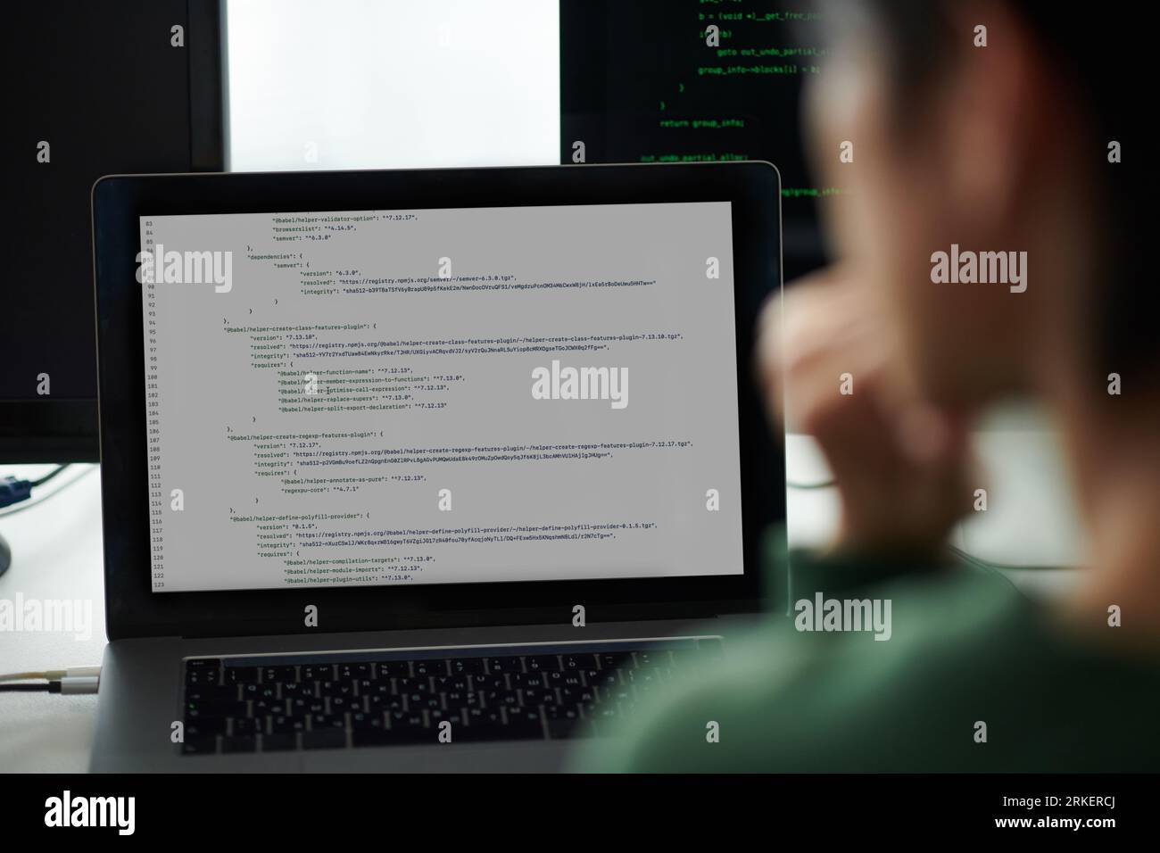 DevOps-Ingenieur, der Programmiercode auf Laptops und Computerbildschirmen untersucht Stockfoto