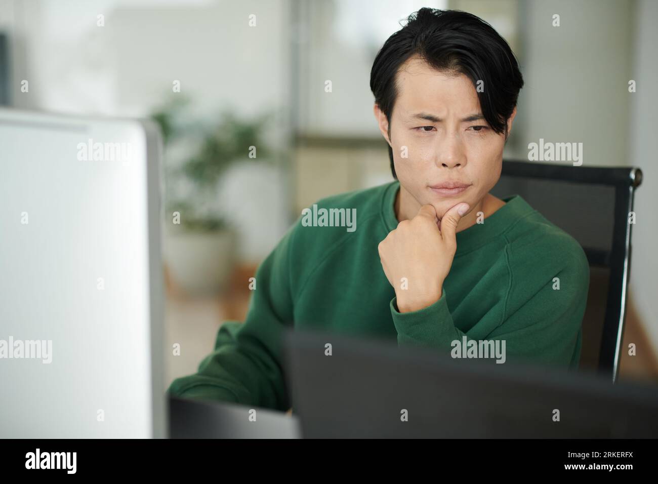 Entwickler, der einen Laptop-Bildschirm mit Programmiercode betrachtet Stockfoto