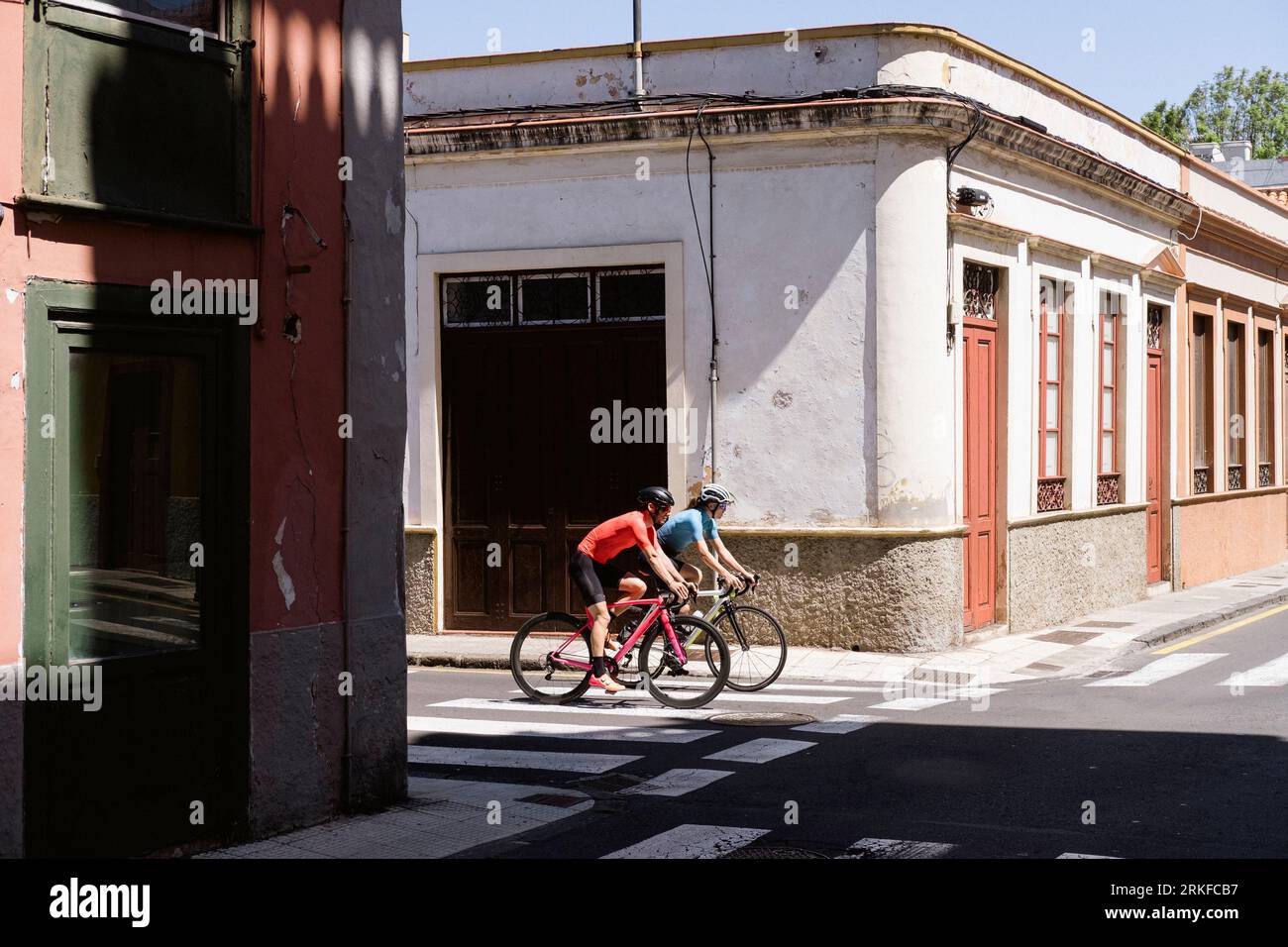 Zwei Radfahrer biegen auf einer kolonialen Stadtstraße ab Stockfoto