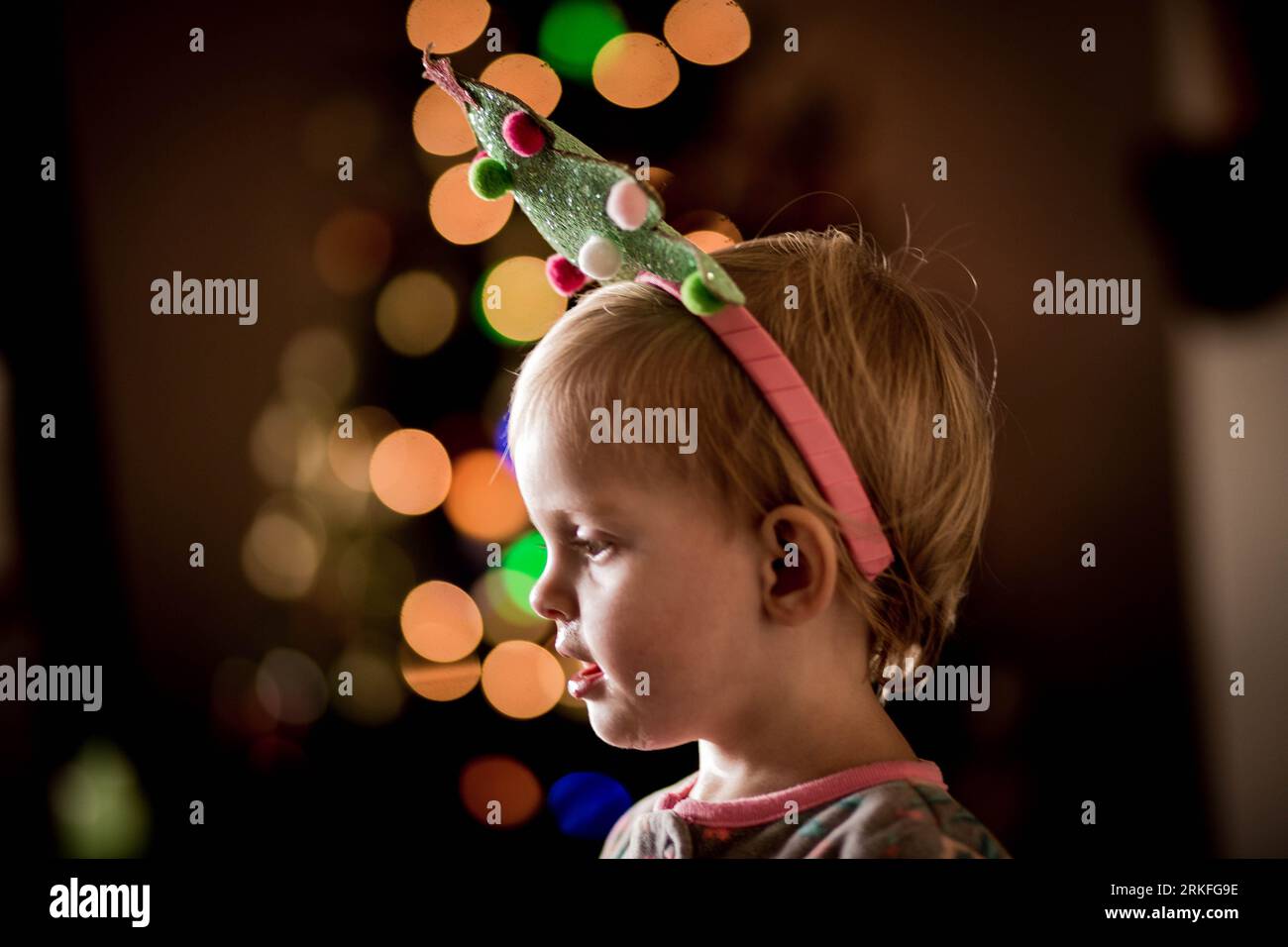 Baby/Kleinkind mit weihnachtsbaum-Stirnband und weihnachts-Bokeh Stockfoto