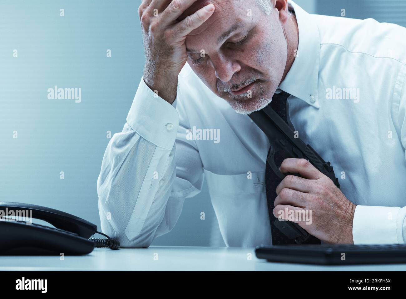 An old employee puts a gun to his throat in the midst of despair. Concept of suicide, helpless major depression, and loneliness. Loss, bereavement, la Stockfoto