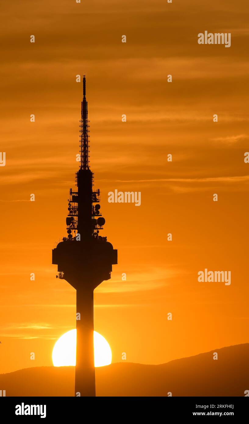 Sonnenuntergang mit dem Sonnenuntergang hinter der Basis eines Kommunikationsturms. Stockfoto