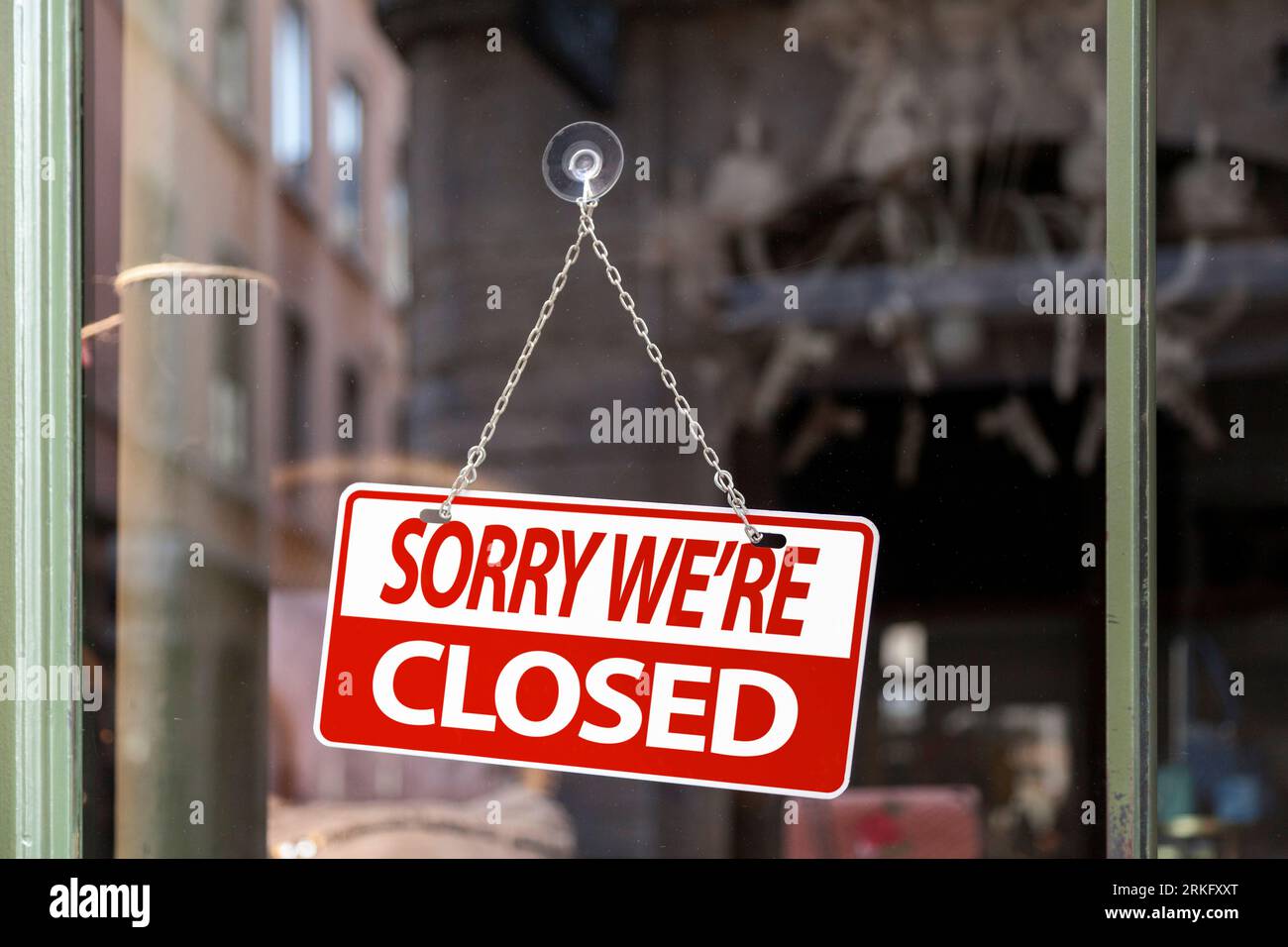 Nahaufnahme auf einem rot-weißen Schild in einem Fenster mit der Aufschrift „Sorry, we are close“. Stockfoto